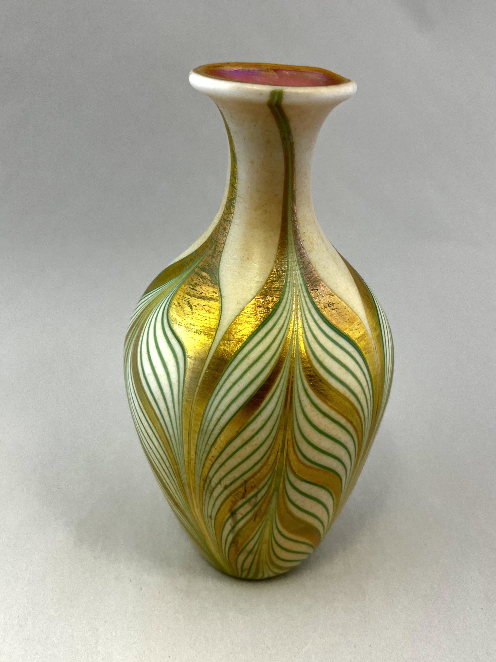 Kew Blas pulled feather glass vase: William Blake urn form glass vase in opal glass with a green and iridescent gold pulled feather, produced at Union glass, signed Kew Blas, 5 1/2" ht. Condition: good with no defects found.