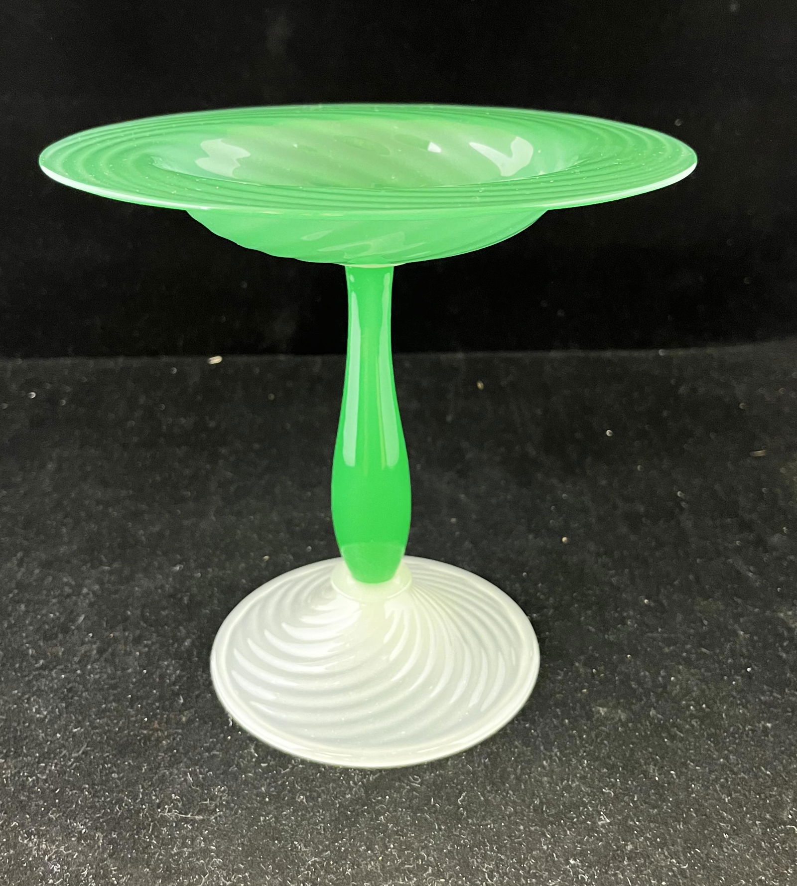 Steuben green Jade compote: Alabaster swirled foot holds a Green Jade swirled compote, 7" ht. Condition: good with no defects found.