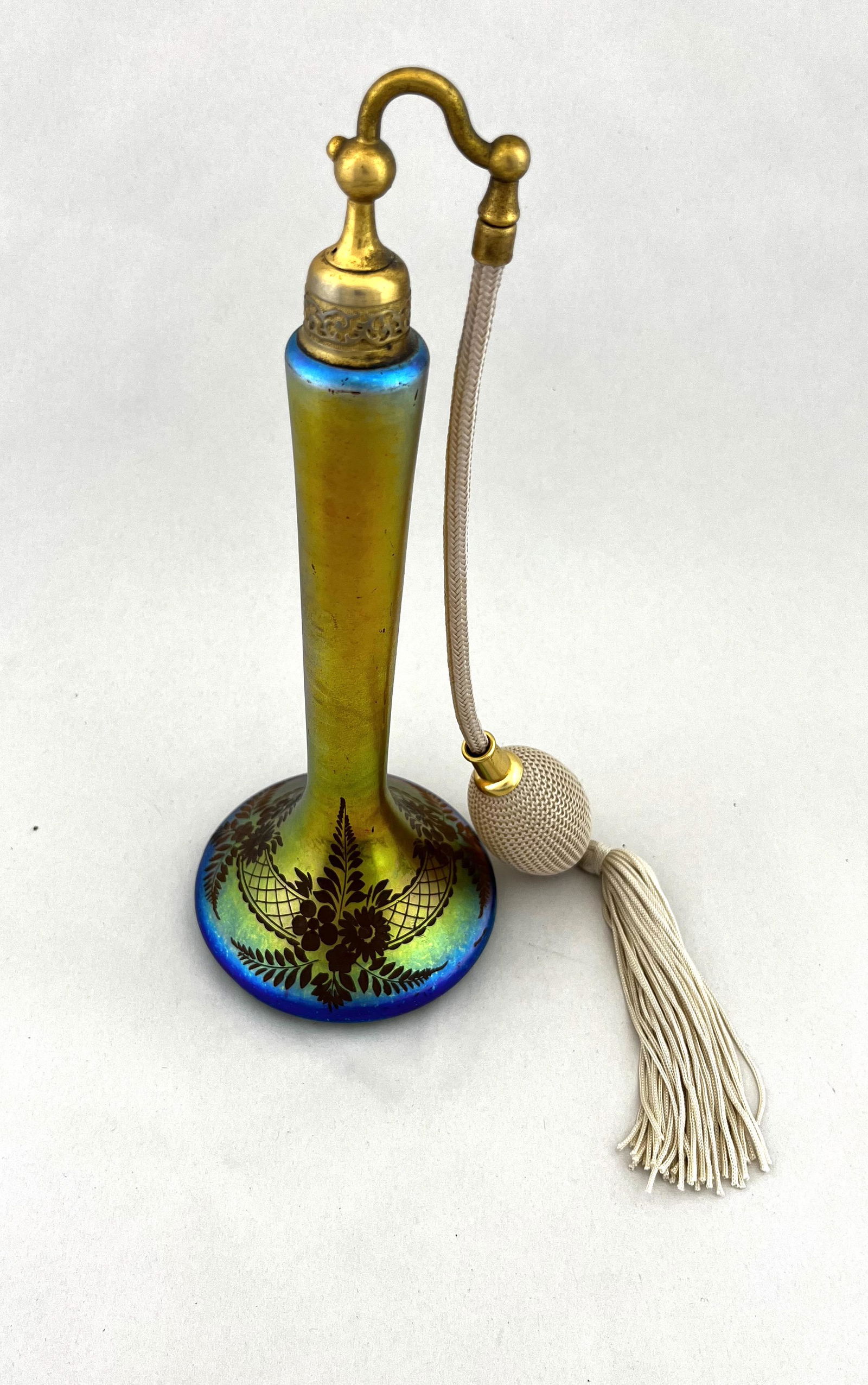 Steuben Gold Aurene atomizer: Footed stick form in Steuben Gold Aurene decorated with intaglio cut flowers and lattice, signed in gold De Viblis, 9 1/2" ht. CONDITION: good with no defects found.