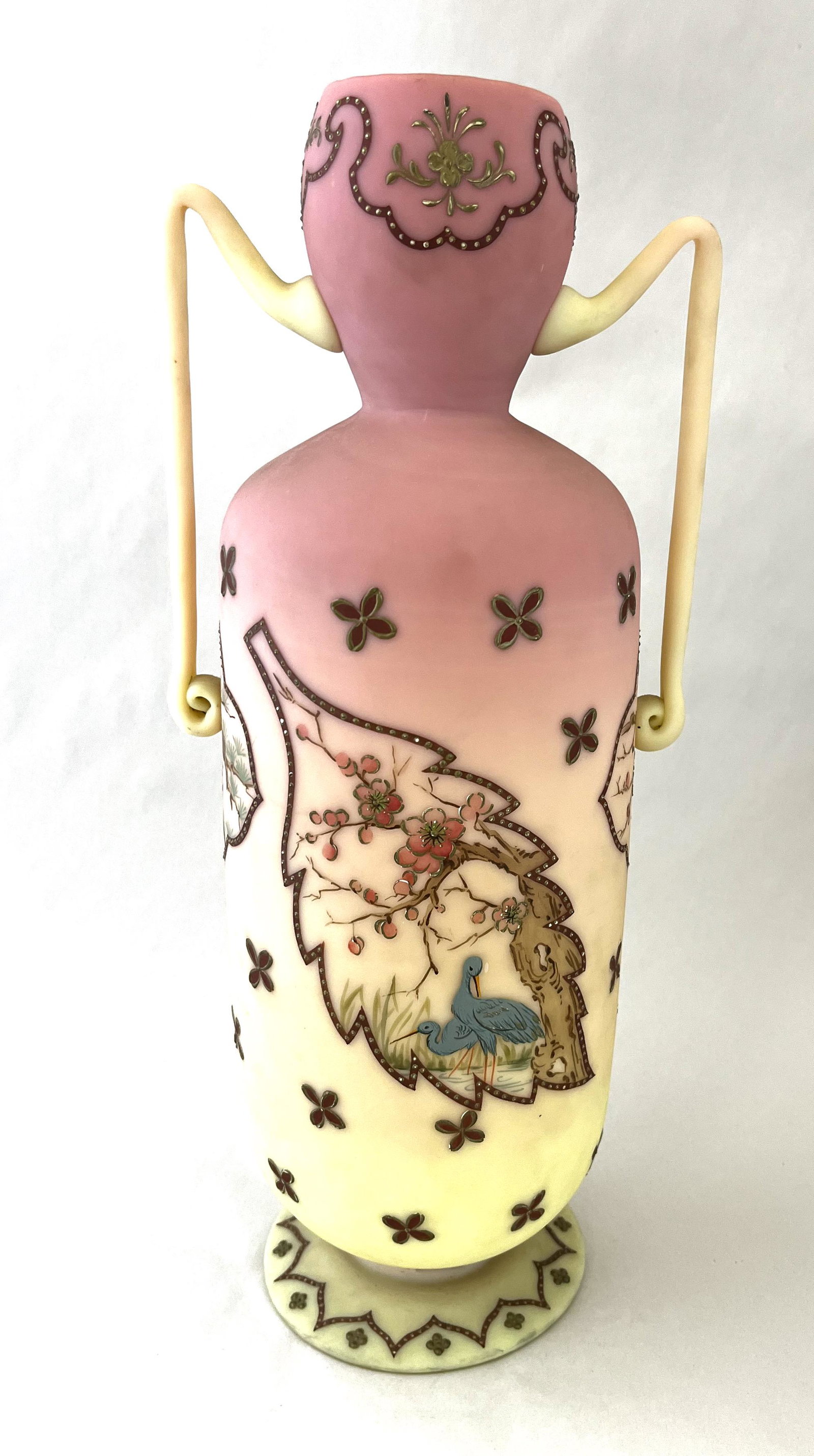 Magnificent Burmese two handle vase: Mt. Washington footed two handle vase decorated with four leaf medallions of birds in forest setting and adorn with four leaf crimson flowers and a Moorish design on the foot and rim, 14" ht. NOTE: pu