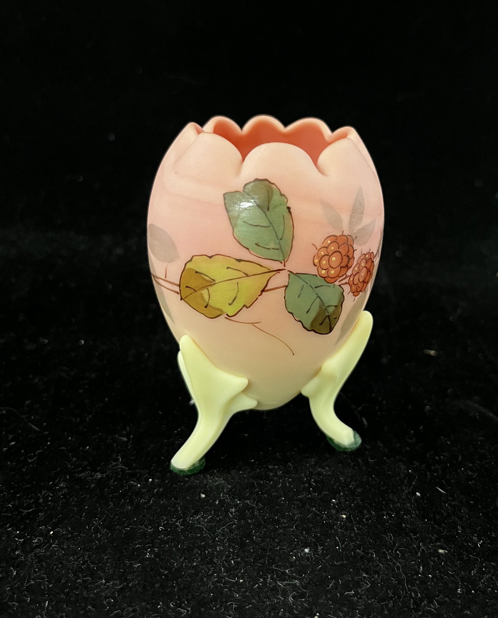 Webb Burmese footed rose bowl: Webb egg form rose bowl in Burmese glass decorated with raspberries and carried on Three reeded feet, 3 1/2" ht. CONDITION: Good with minor chipping to the feet