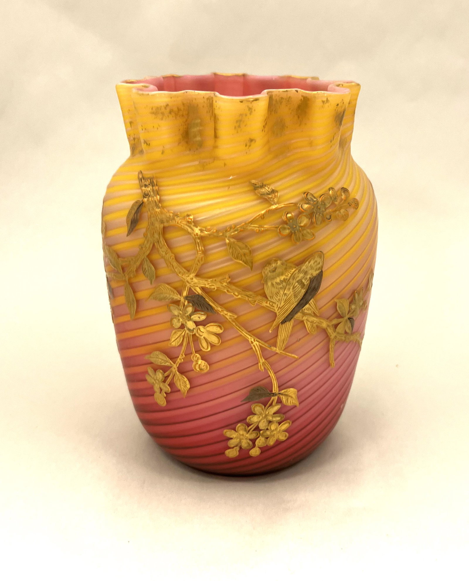 Stevens/Williams Pompeian Swirl vase: Stevens and Williams Pompeian Swirl vase with a crimped top in rose to yellow decorated with a cascading gilt branch with song bird, with two butterflies on the reverse, 6 1/2' ht. CONDITION: good wit