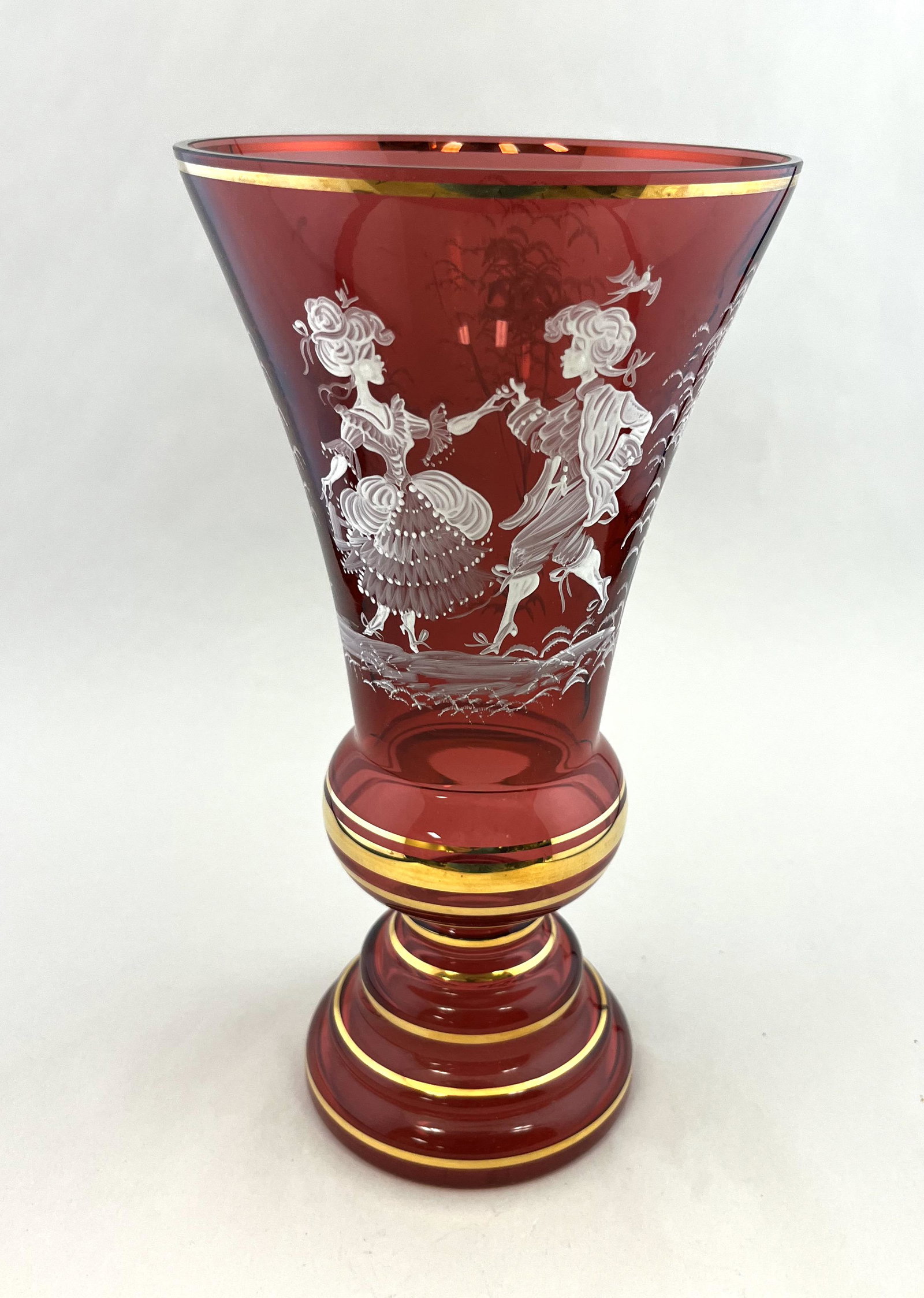 Mary Gregory cranberry glass vase: Mid Century cranberry glass vase with a Mary Gregory design of a dancing couple, 11" ht. CONDITION: good with no defects found.