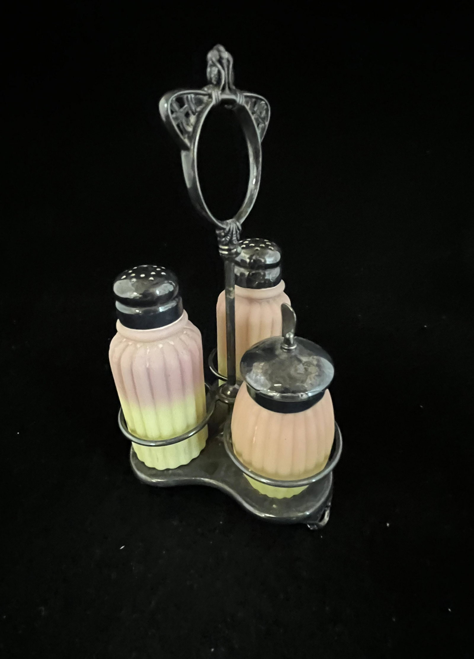 Mt. Washington Burmese condiment set: Mt. Washington ribbed pillar Burmese condiment set consisting of two shakers and a mustard set in a marked Pairpoint caddy, 8" ht. CONDITION: good with no defects found.