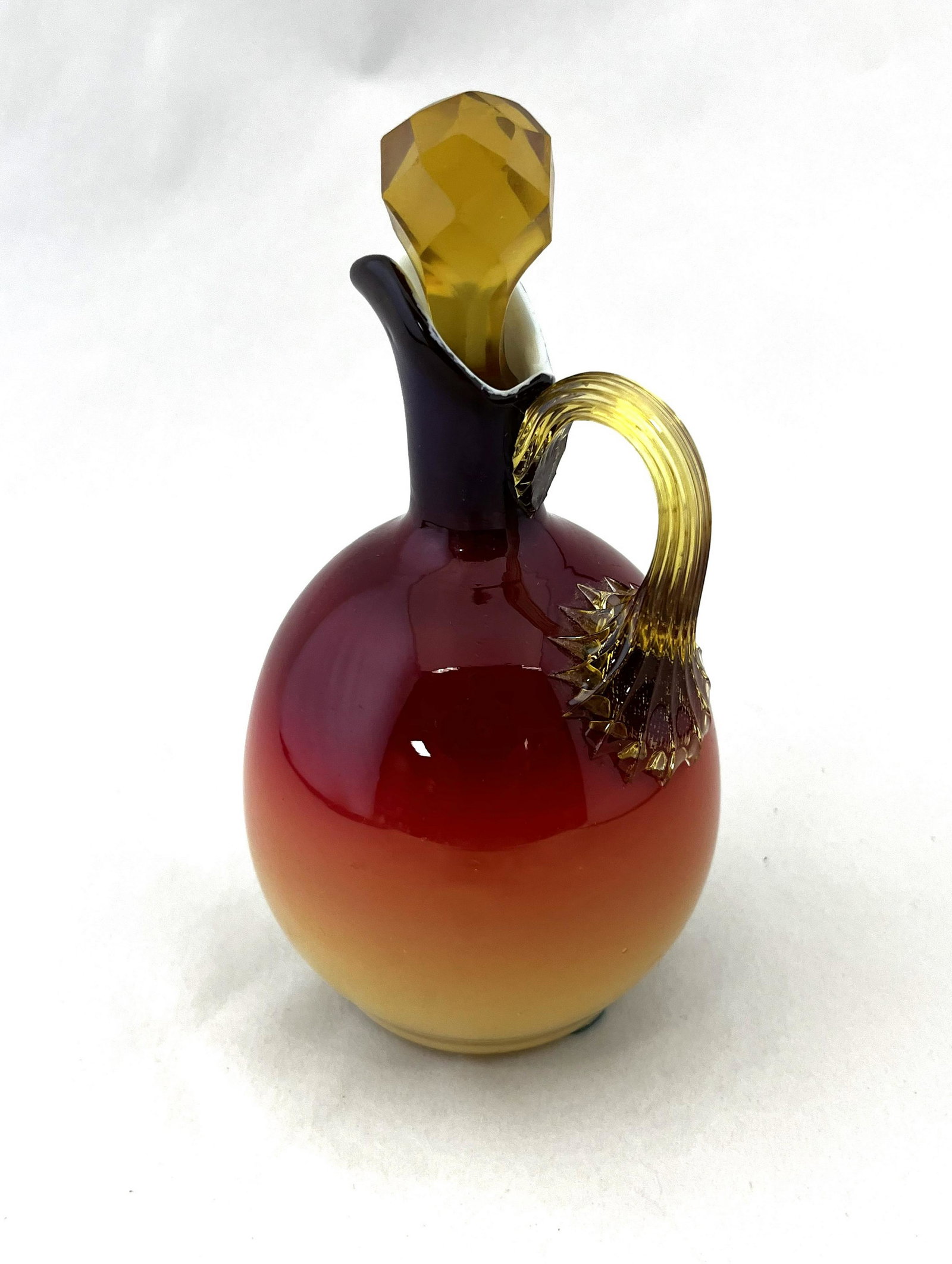 Wheeling Peachblow cruet: Wheeling Peachblow cruet in a glossy finish, fitted with a faceted stopper and reeded handle, 6 1/2' ht. CONDITION: stopper with chip to base.