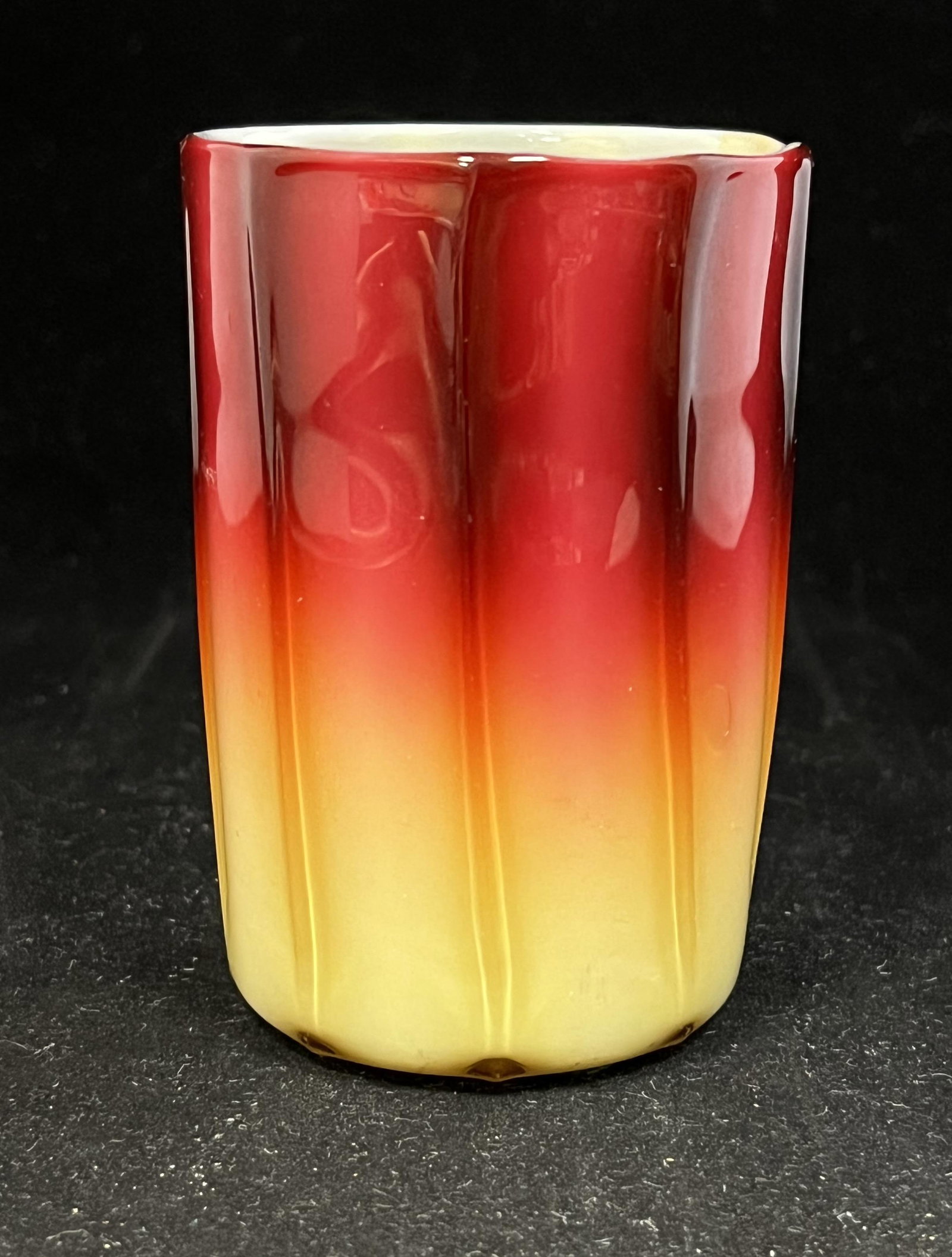 New England Plated Amberina tumbler: New England Plated Amberina glass ribbed tumbler in a glossy finish, 3 3/4" ht. CONDITION: Good with no defects found but one closed bubble on the side.