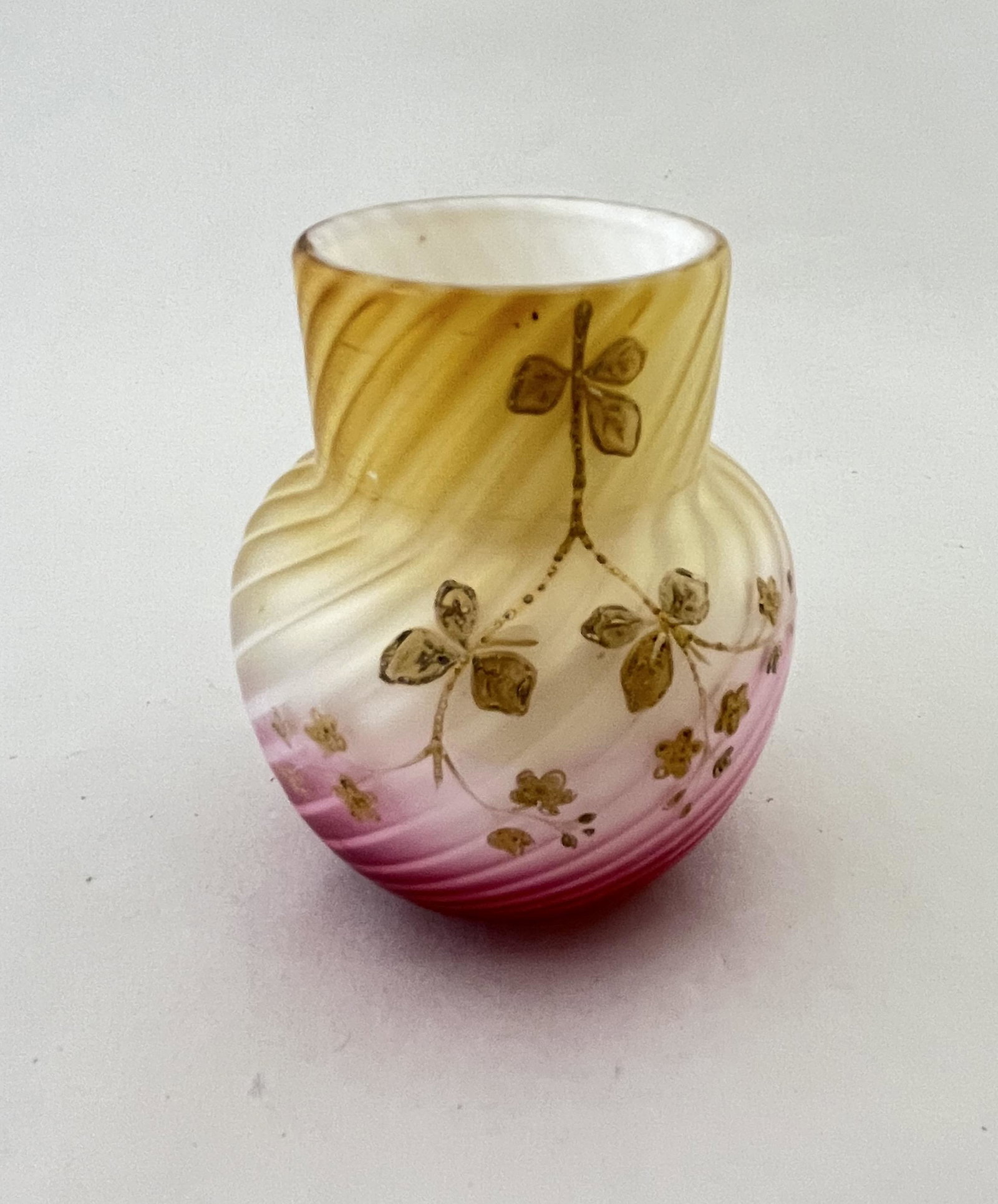 Stevens and Williams Pompeian vase: Stevens and Williams Pompeian Swirl amber to rose glass vase with gold cascading vine, 4 1/2" ht. CONDITION: Good minor gold loss