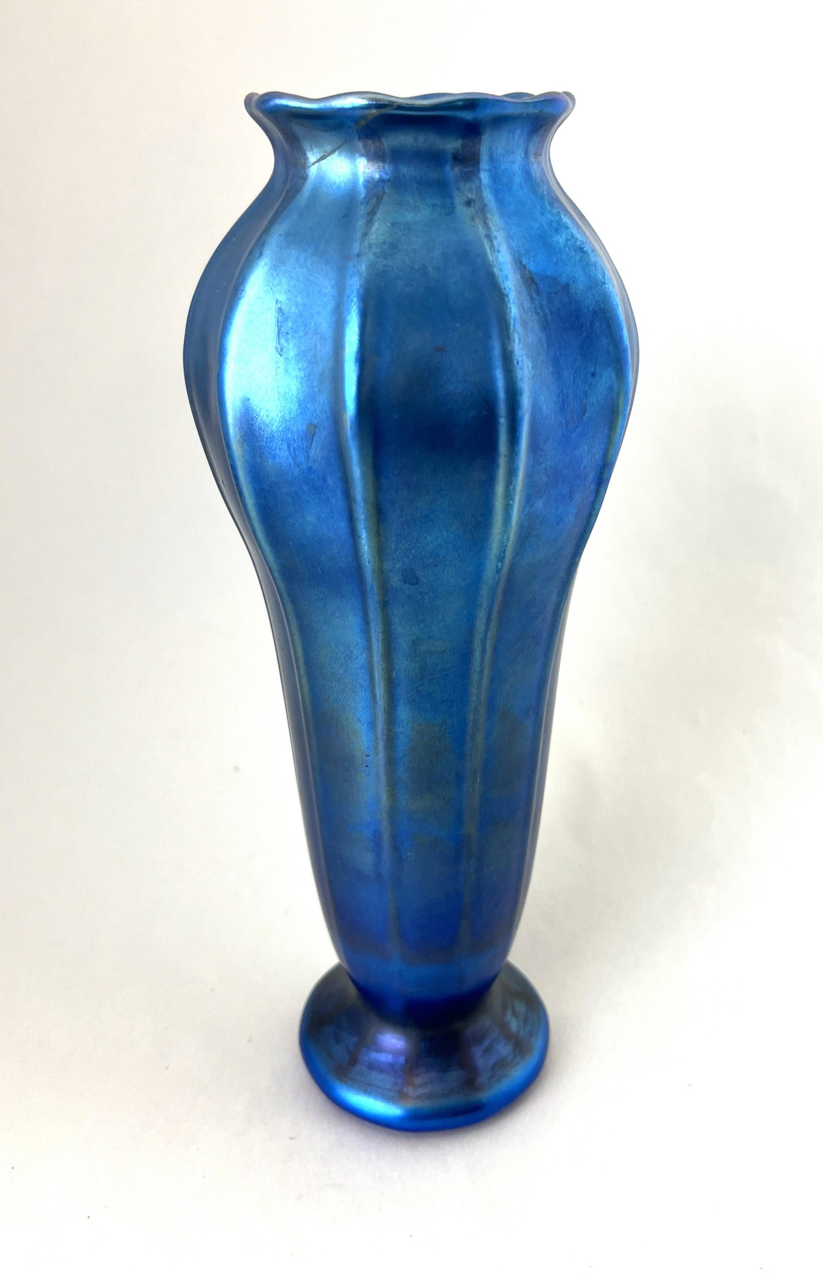 Tiffany Blue Favrile glass vase: Tiffany footed Blue Favrile glass vase with exaggerated ribs, signed M L. C. Tiffany Favrile, 10 1/2" ht. CONDITION: Good but with a color line at the rim.