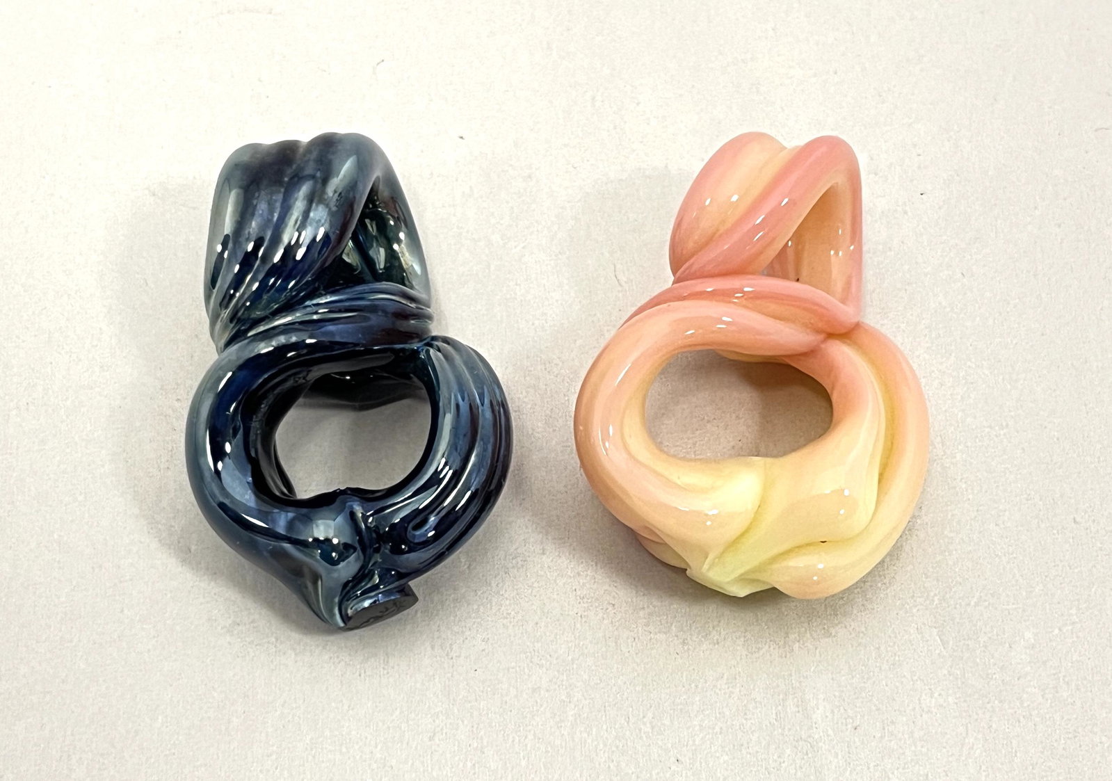 Two Lotton free form pendants: Two free form twist Lotton pendants one in iridescent blue the other in a rare Burmese, both signed Lotton, 1 3/4" ht. CONDITION: Good with no defects found