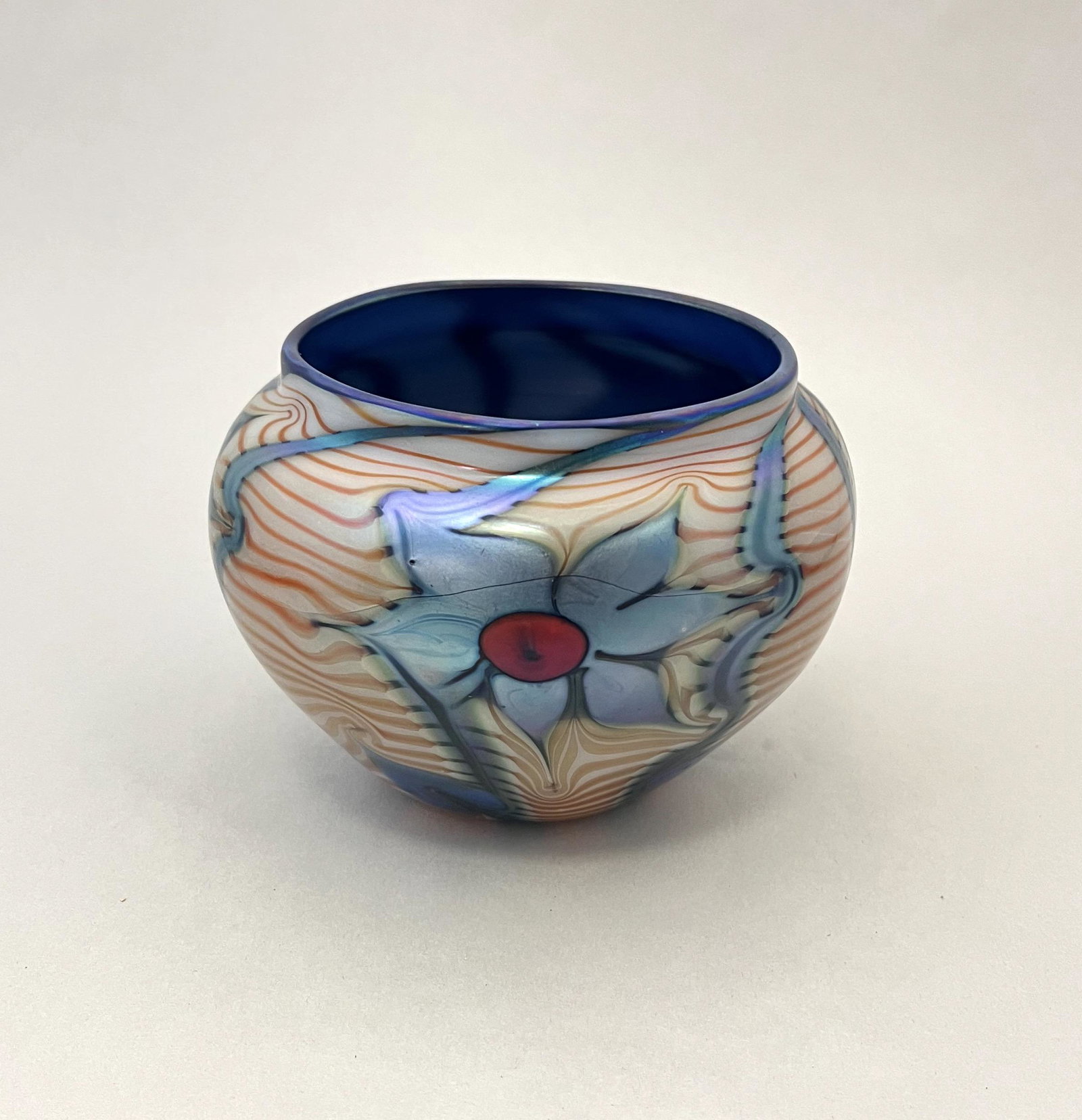 Orient and Flume art glass vase: Ovoid form in blue glass decorated with a blue central flower on a opal ground, 4" ht. CONDITION: large crack to the body.