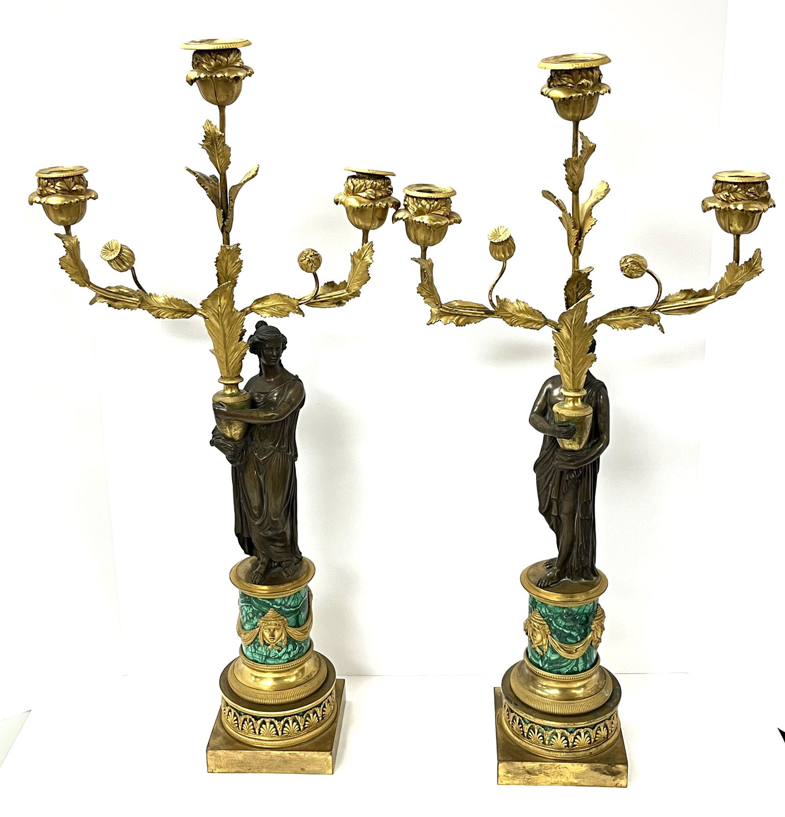 Pair of Malachite and Bronze Candelabra: Pair of Malachite and bronze candelabras with bronze Romanesque figures, one with female figure 26 1/2" ht, with male 26" ht. CONDITION: no chips, cracks, repairs or material defects found. Jaremos at