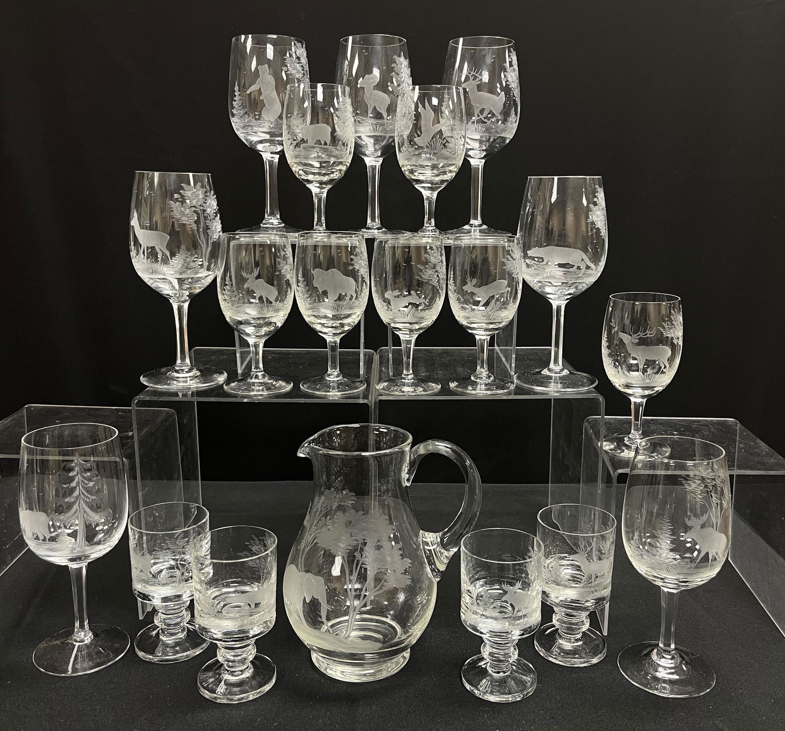 19 Moser etched glass items: 19 glass bar items each etched with animals and trees consisting of red and white wine goblets a pitcher and footed cordials attributed to Moser, tallest goblet 7 1/4" ht. CONDITION: no chips, cracks,