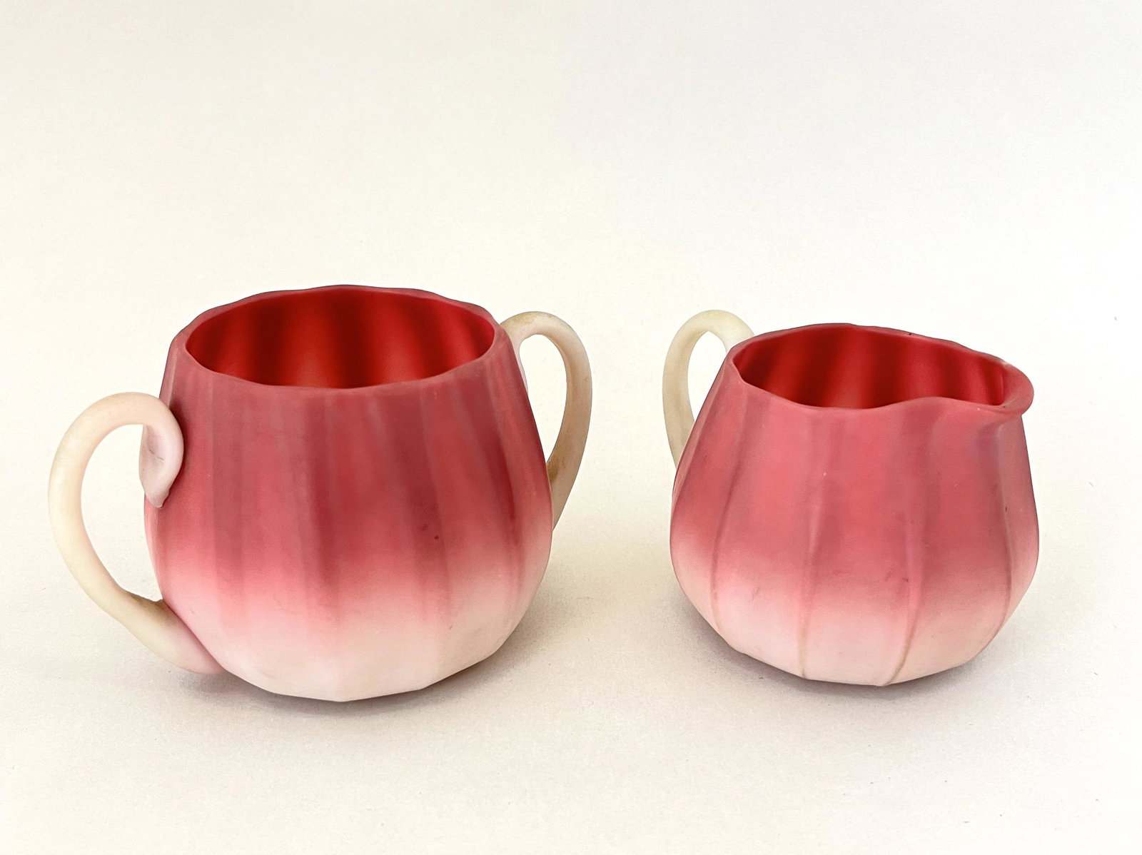 New England Peachblow cream and sugar: New England Peachblow cream and sugar with exaggerated ribs, 2 3/4" ht. CONDITION: no chips, cracks, repairs or material defects found. Jaremos attempts to call any material flaw that affects the pric
