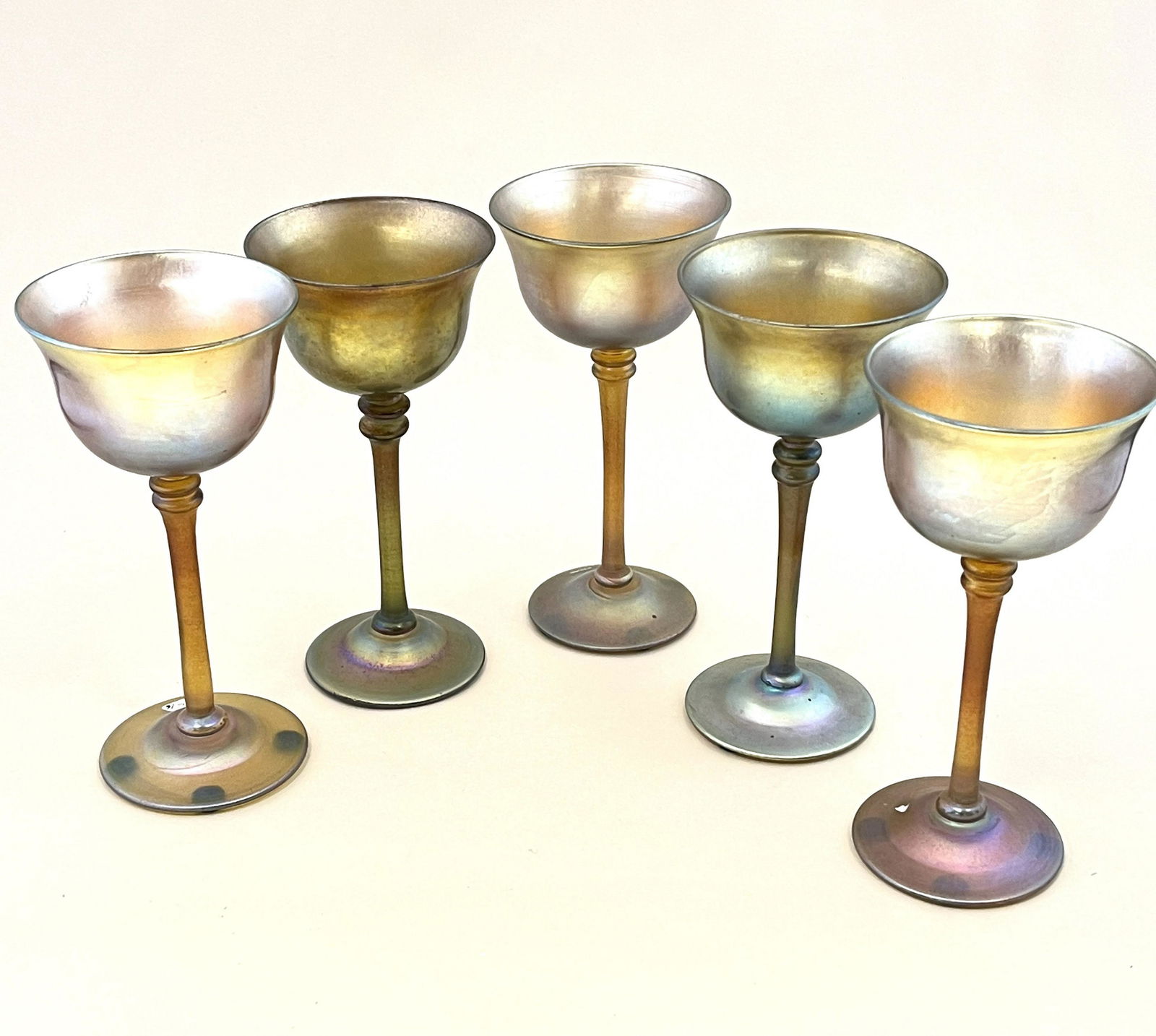 Set of five Tiffany goblets: Set of five Tiffany Gold Favrile glass goblets, each signed, 6 1/8" ht. CONDITION: no chips, cracks, repairs or material defects found. Jaremos attempts to call any material flaw that affects the pric