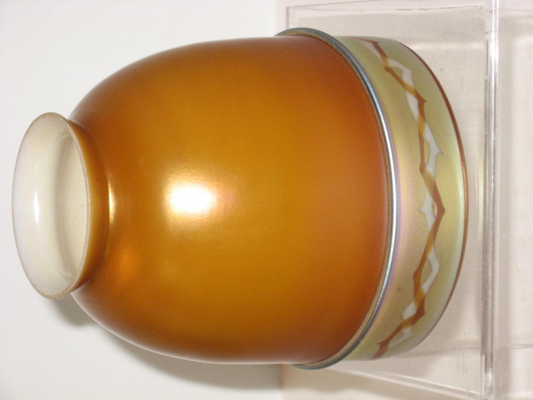 Rare Steuben Intarsia art glass shade,: brown Aurene shade cased in white decorated with an iridescent gold Aurene border with a zigzag pattern, unsigned, 5" ht. CONDITION: small exterior chip to fitter.