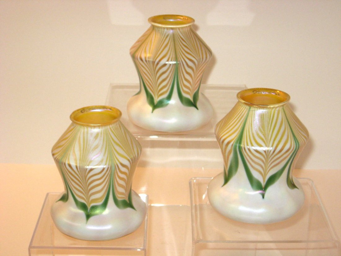 Three matching Quezal glass shades,: opal optic ribbed decorated with iridescent gold and green pulled feathers, each singed Quezal 5 1/4" ht. CONDITION: good with great color no chips, cracks or repairs.