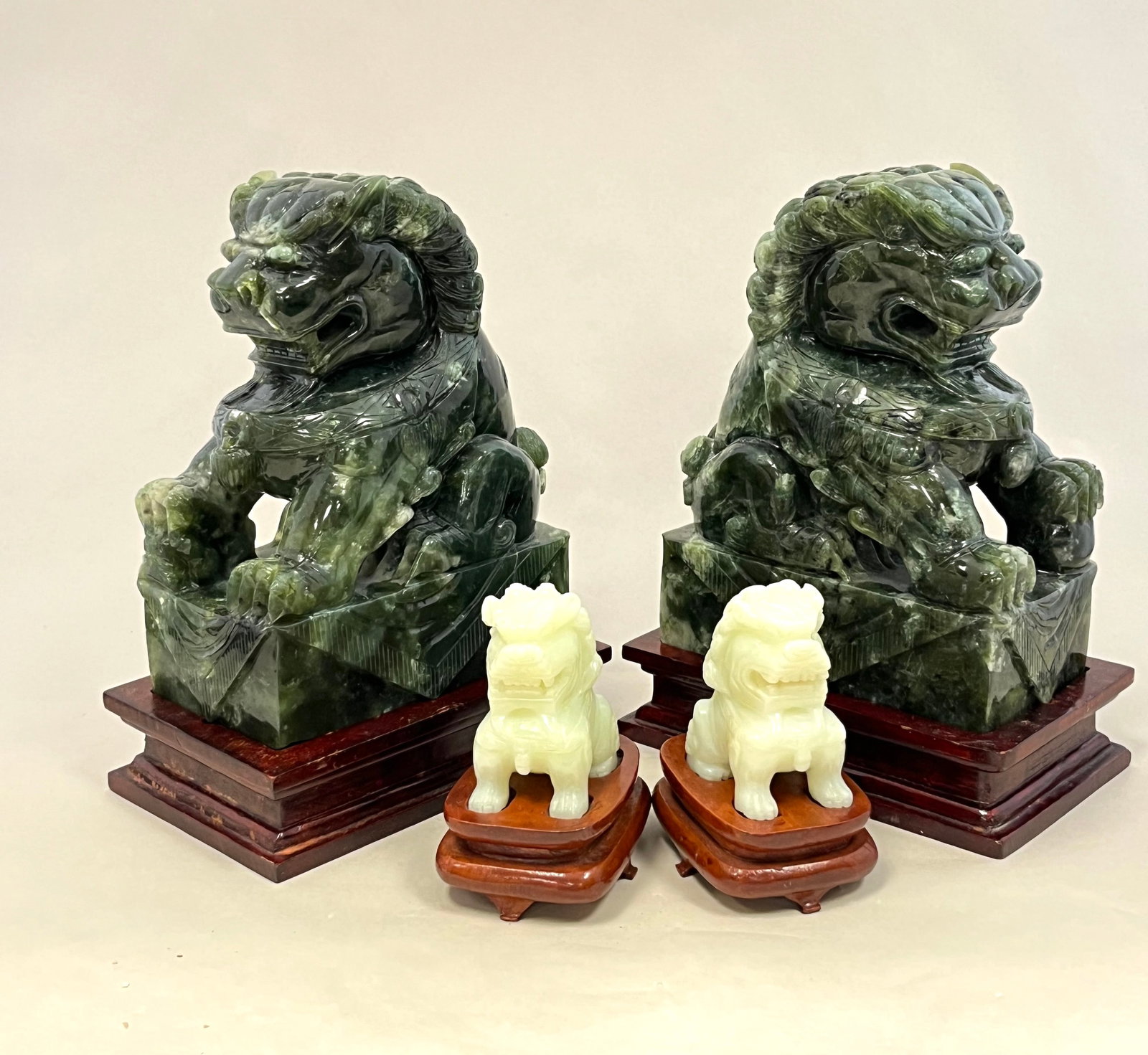 Two pair of Pho Dogs: Two pair of Pho dogs one in Green stone the other in white, all fitted with wood bases, including a green and white Jade, without base 6 1/2" high CONDITION: minor wear on the Jade.