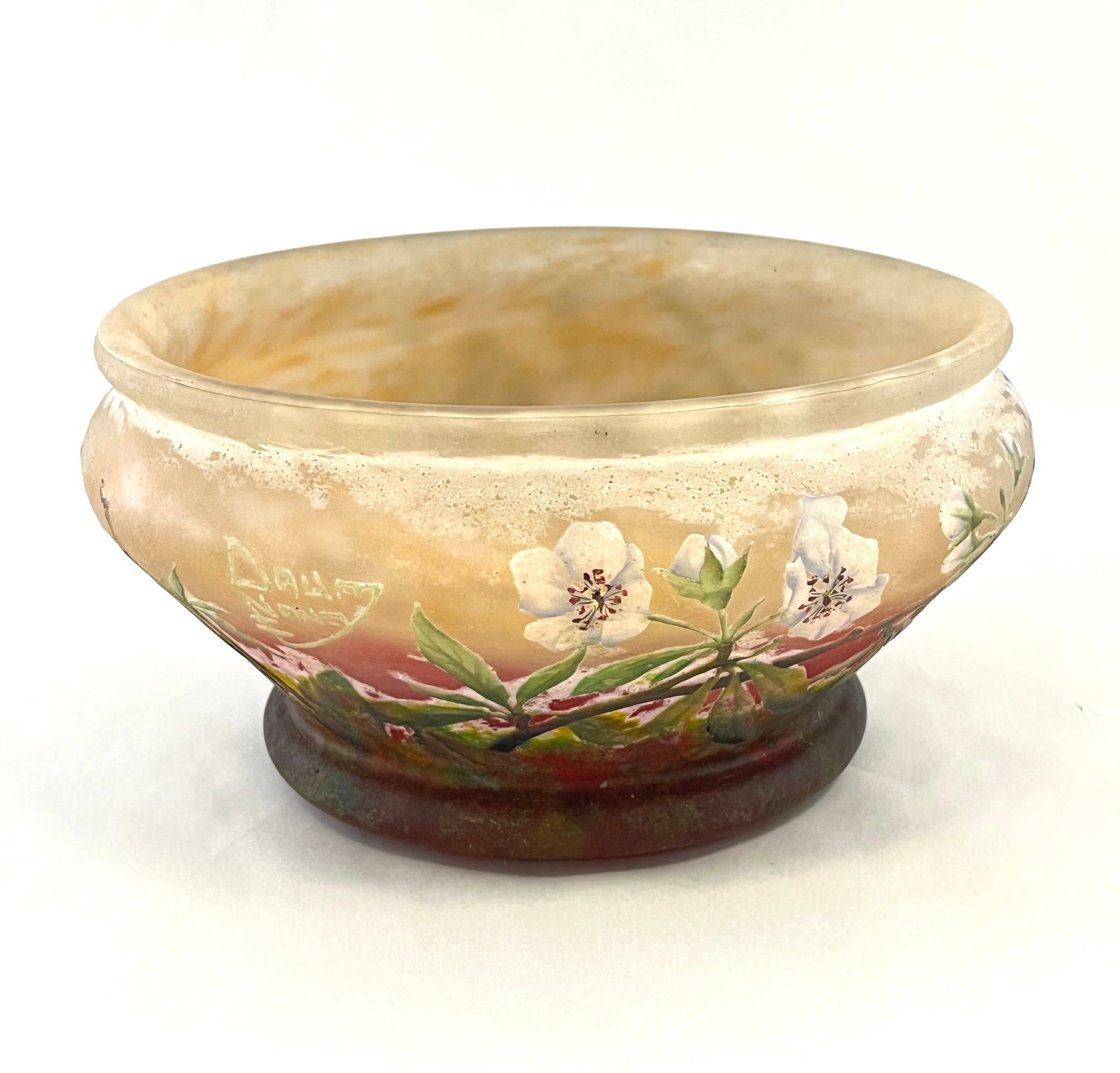 Daum Nancy French cameo bowl: Daum Nancy French cameo glass bowl in mottled red graduating to a yellow rim decorated with white dogwood blossoms, signed in cameo Daum Nancy, 7" wide. CONDITION: professional repair to the foot, see