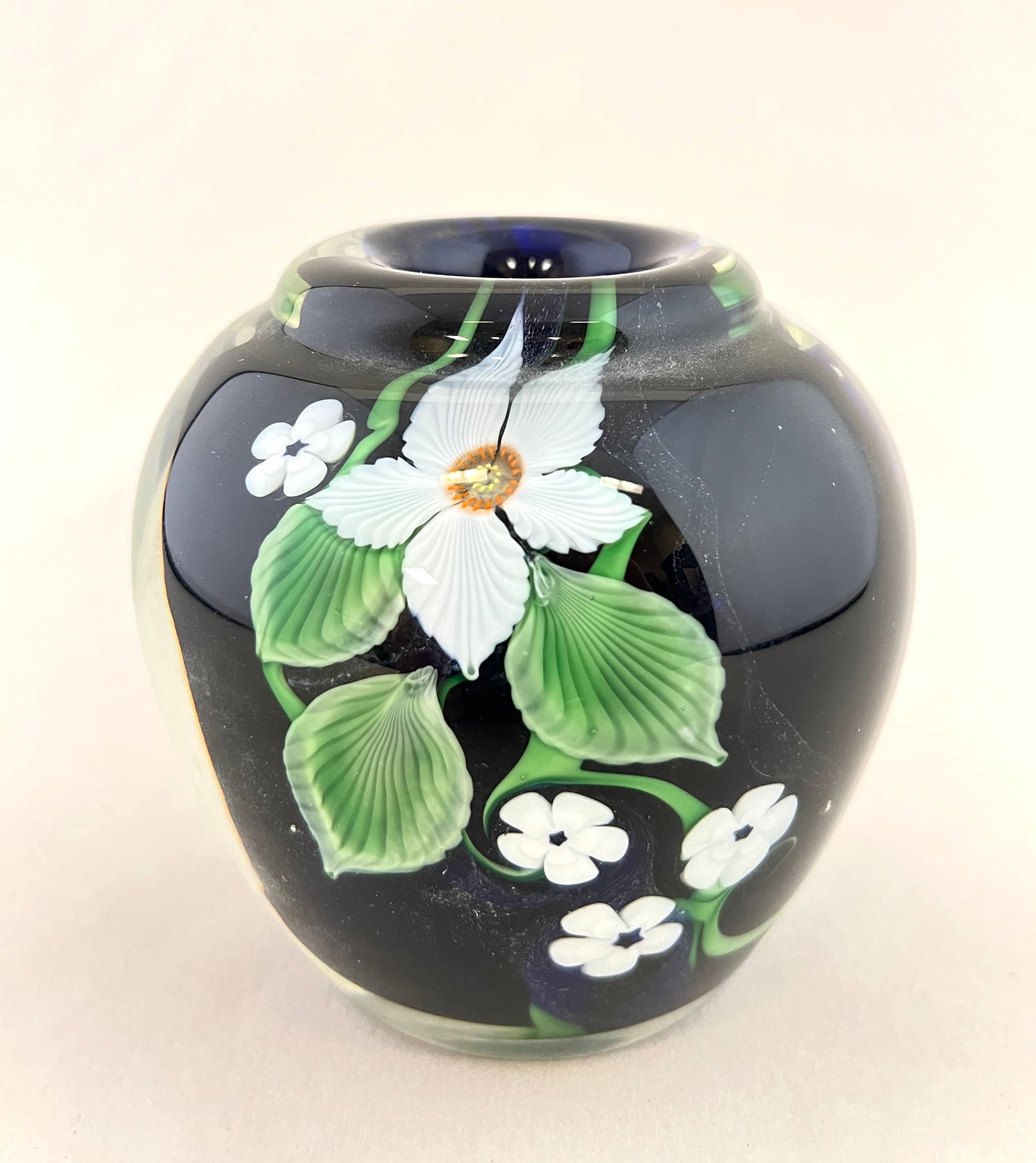 Orient and Flume glass vase: Orient and Flume paperweight glass vase in dark black decorated with white flowers, signed OF 1983, 3 1/2" ht. CONDITION: no chips, cracks, repairs or material defects found. Jaremos attempts to call 