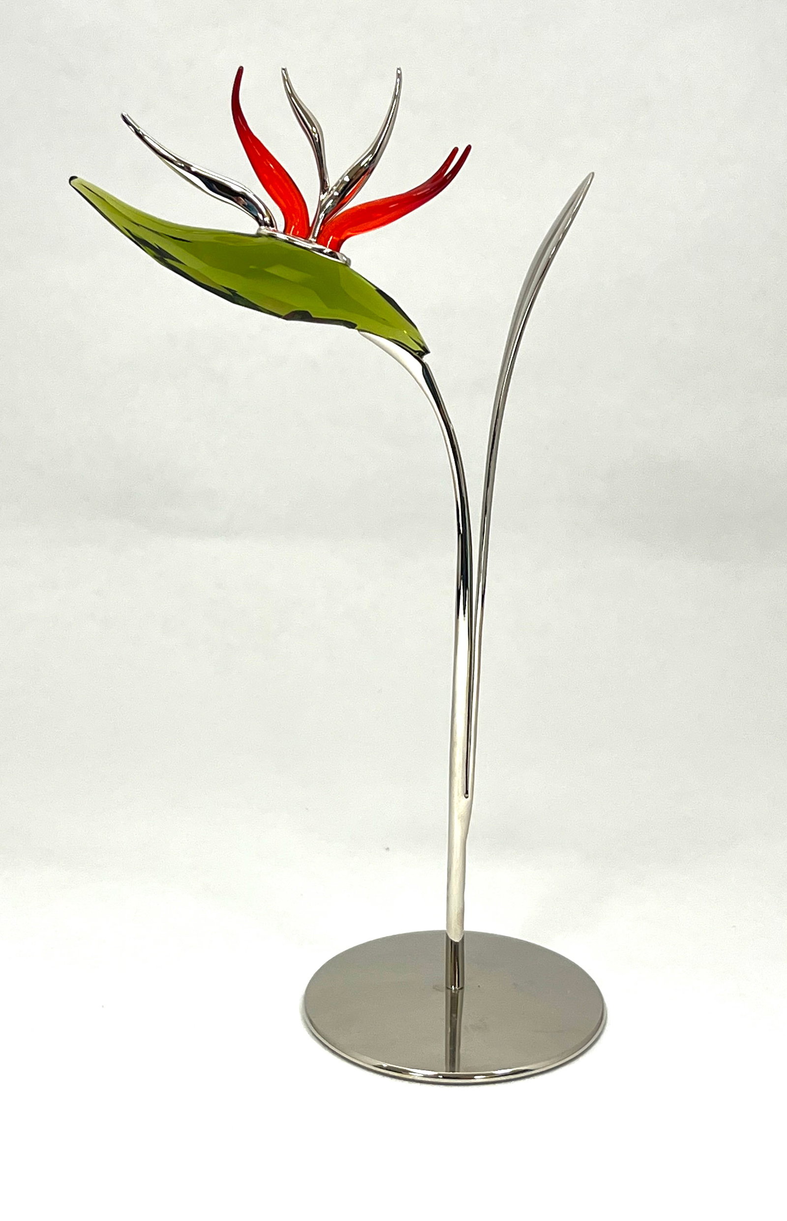 Swarovski glass and metal flower: Swarovski Dalmally olive flower set in a metal stand, with original gift box. 8" ht. CONDITION: no chips, cracks, repairs or material defects found. Jaremos attempts to call any material flaw that aff