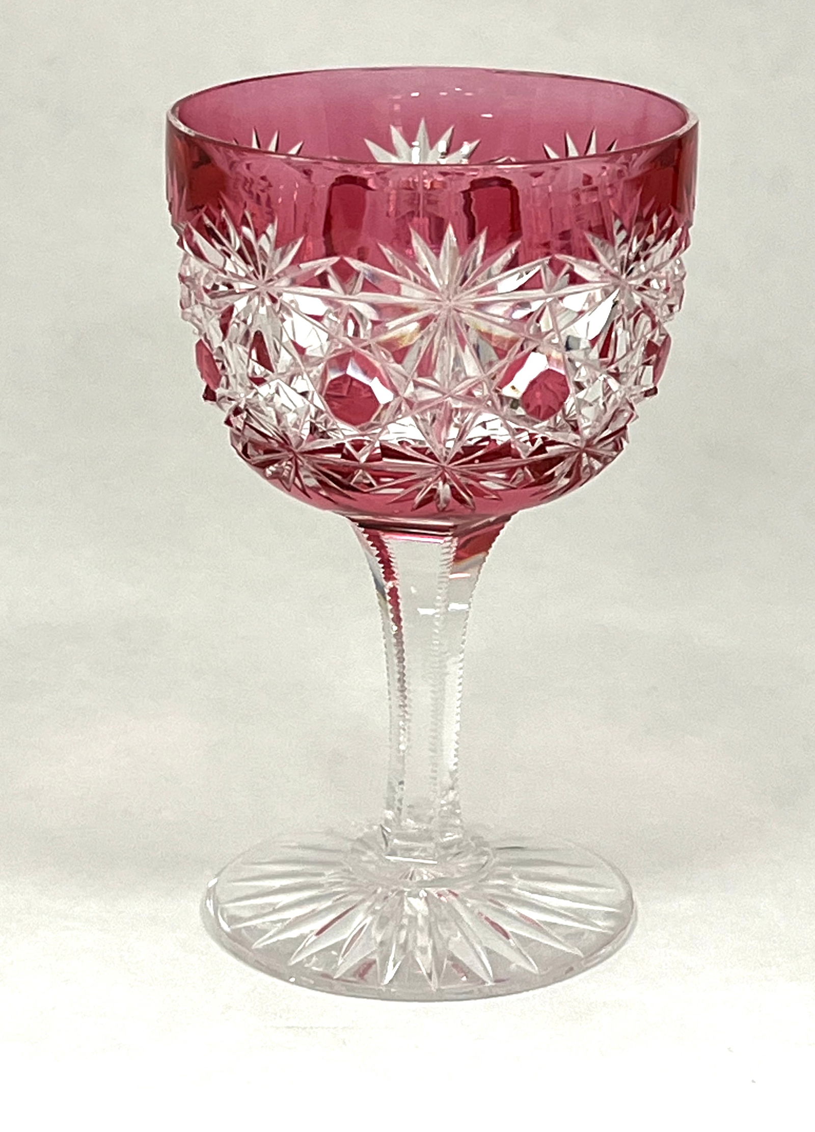 Dorflinger ruby cut to clear goblet: Dorflinger ruby cut to clear goblet in a Russian cut pattern with a notched stem, Ht. 4 1/2". CONDITION: no chips, cracks, repairs or material defects found. Jaremos attempts to call any material flaw