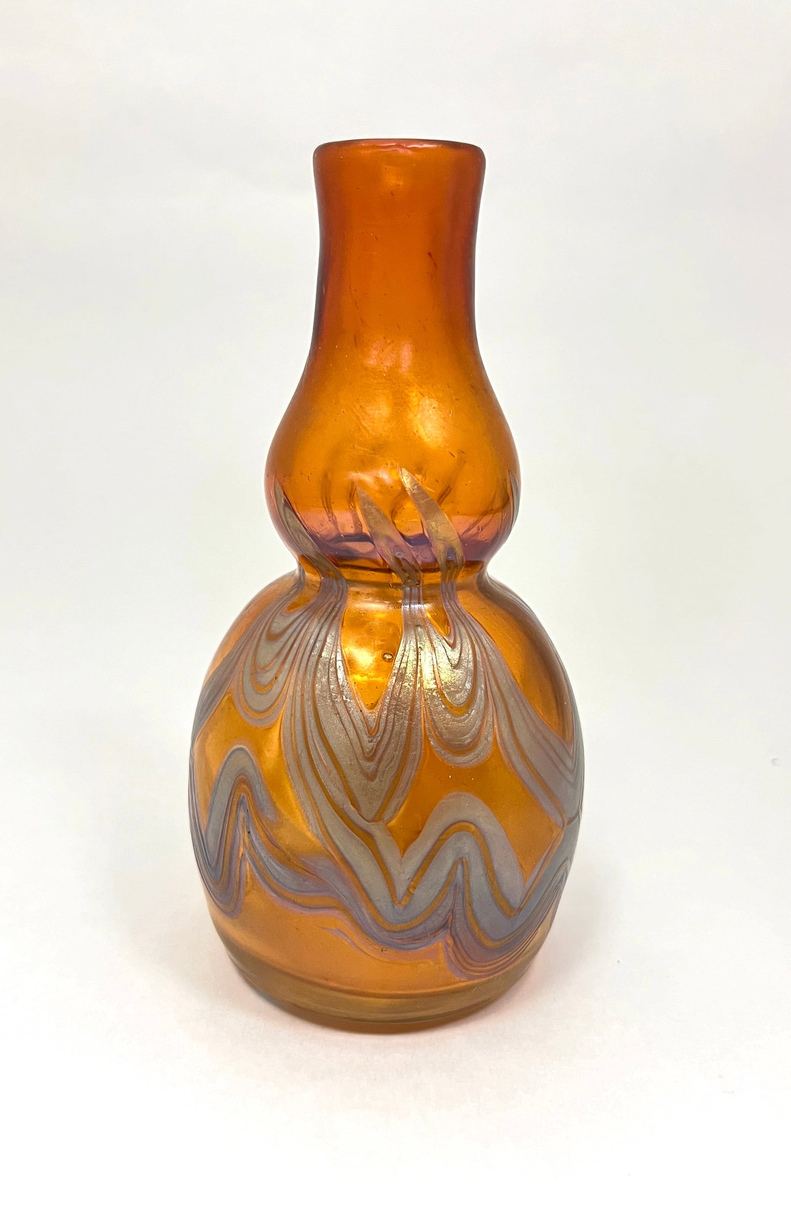 Loetz Phanomen Genres glass vase: Loetz amber bottle form glass vase with a iridescent blue pulled feather, PN I-8050, signed Loetz Austria, 5" ht. CONDITION: no chips, cracks, repairs or material defects found. Jaremos attempts to ca