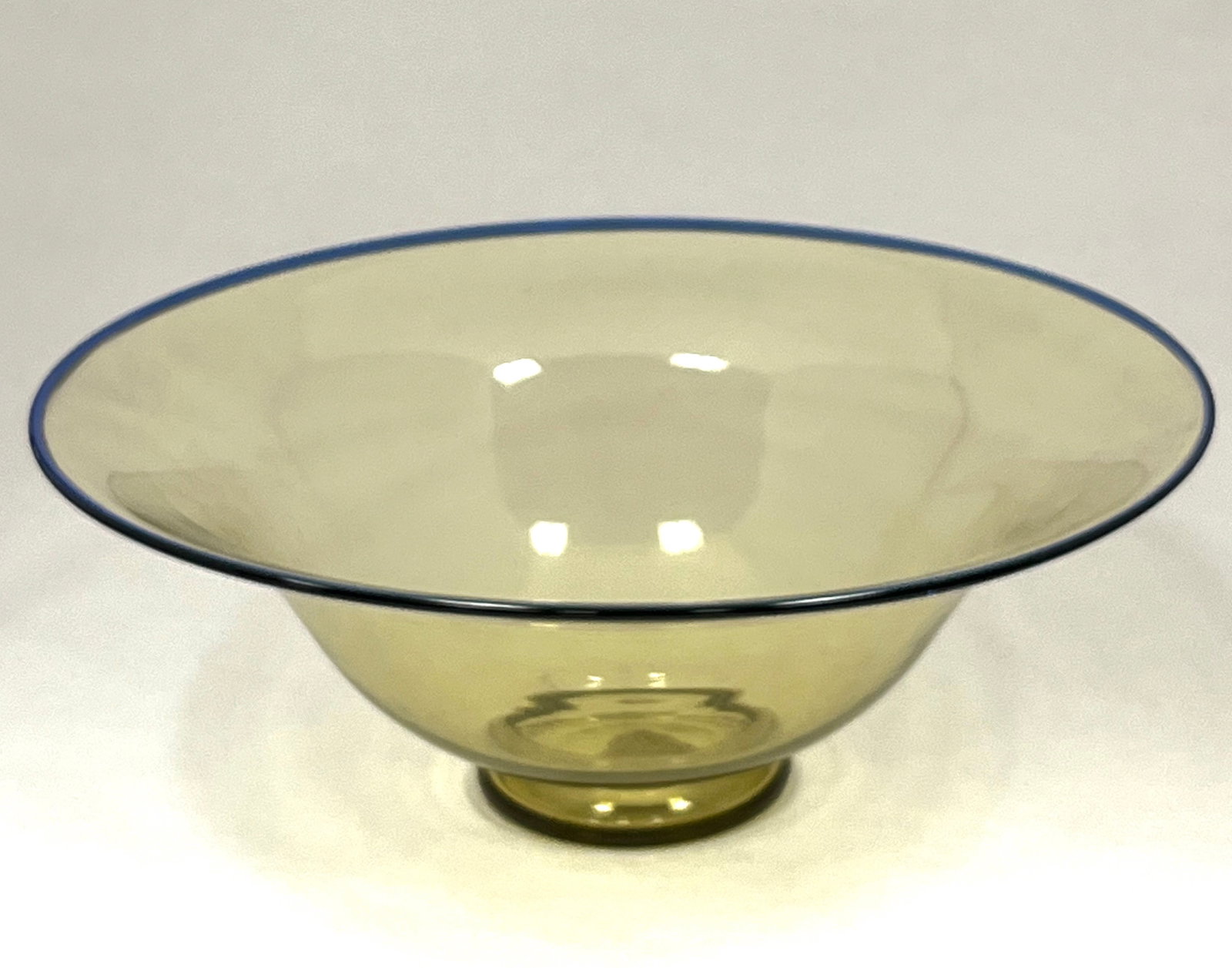 Steuben amber glass bowl: Steuben amber glass bowl with blue lip wrap, carries an original paper label, 10" wide. CONDITION: no chips, cracks, repairs or material defects found. Jaremos attempts to call any material flaw that 