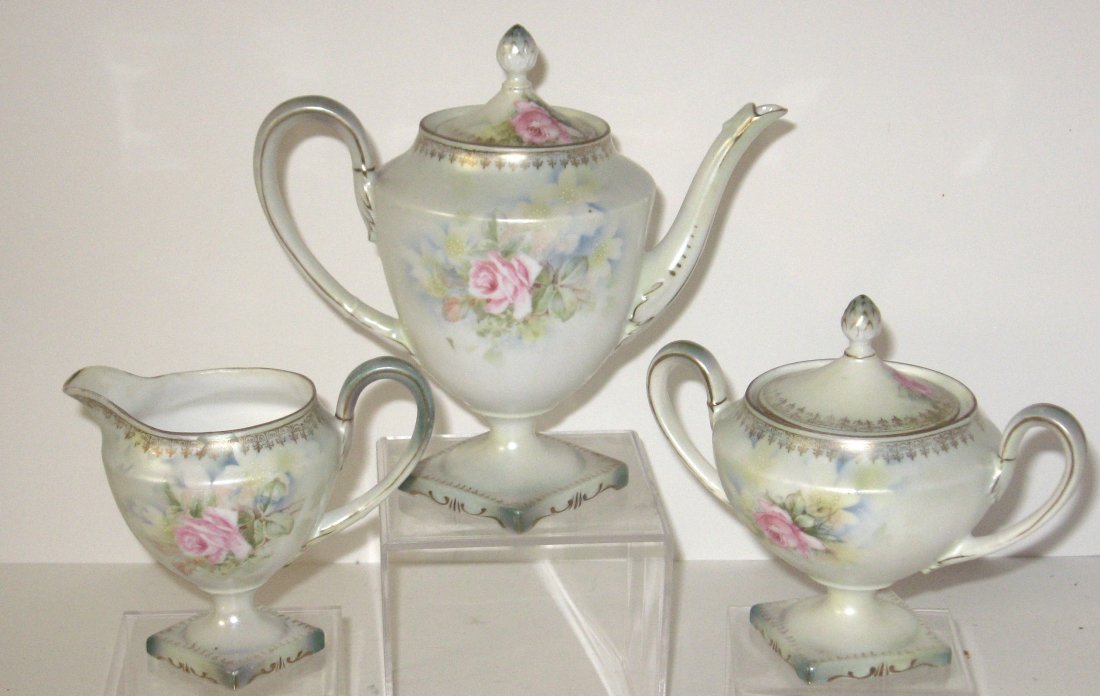 R. S. Prussian tea set,: consisting of a tea pot, cream and covered sugar bowl each decorated with flowers, one piece marked, tallest 9" ht.
