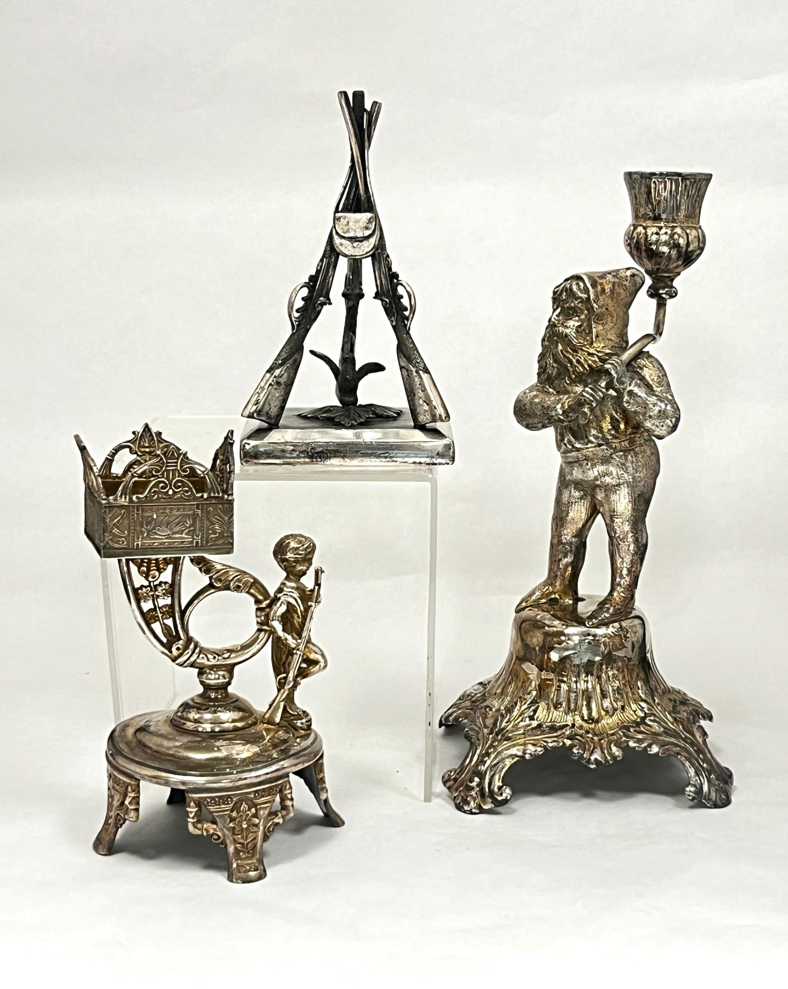 3 piece grouping of Pairpoint metal: 3 piece grouping of Pairpoint metal including a figural dwarf candlestick, a gun paperweight, and a Kate Greenway figural caddy, tallest 10" ht. CONDITION: minor wear, no chips, cracks, repairs or mat