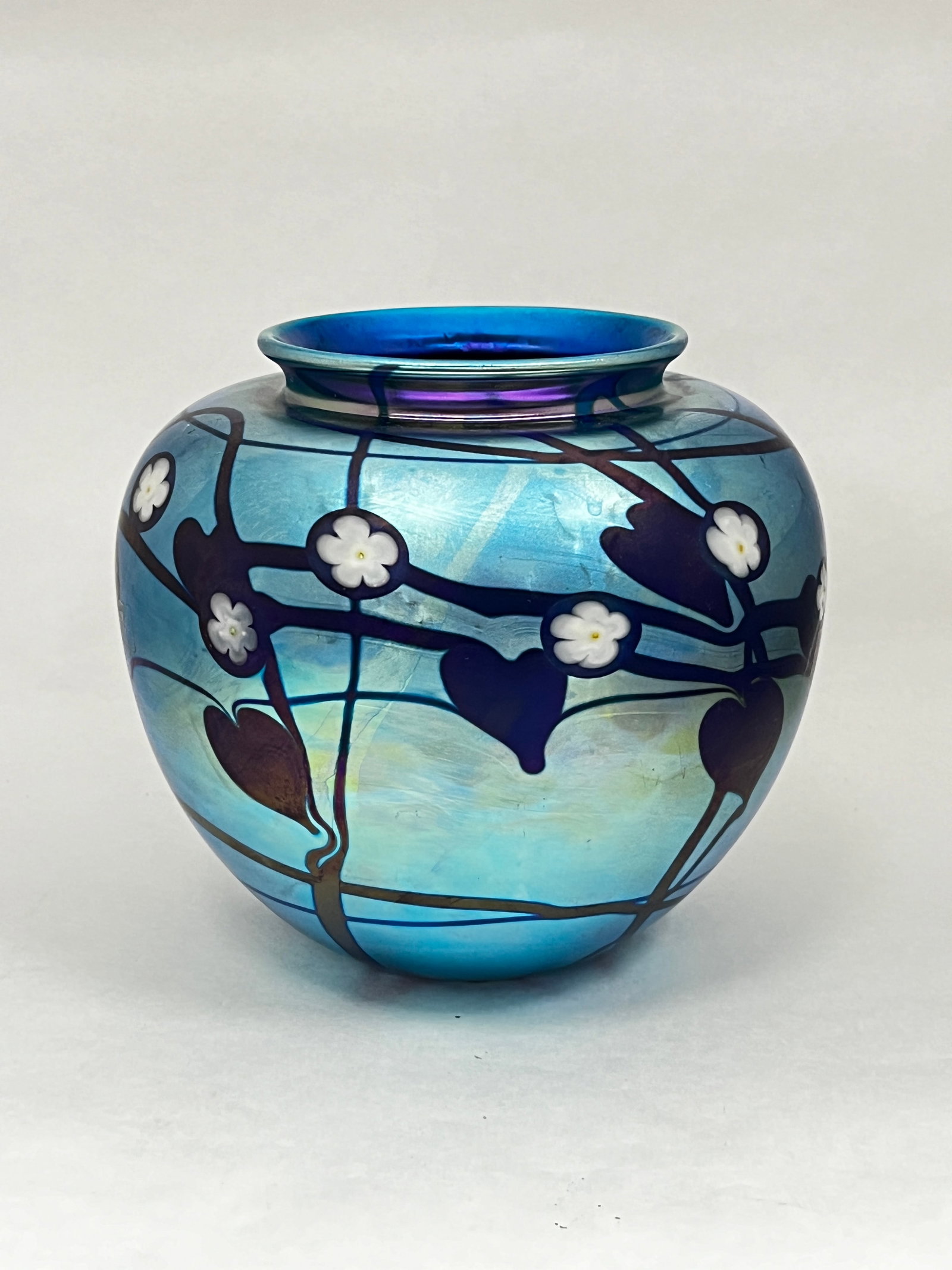 Donald Carlson blue glass vase: Donald Carlson iridescent blue art glass vase with dark cobalt hearts and vines and white millefiori, signed Carlson SP 83, 6" ht. CONDITION: no chips, cracks, repairs or material defects found, Jarem
