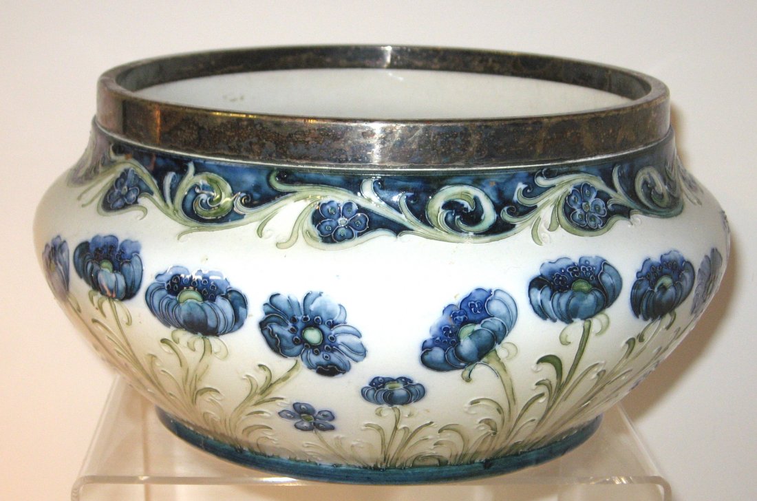 Large Moorcroft Macintyre Florian bowl,: silver rim bowl in opal decorated with blue poppies on green stems, marked with the Macintyre back stamp and initialed by William Moorcroft, 10" wide.