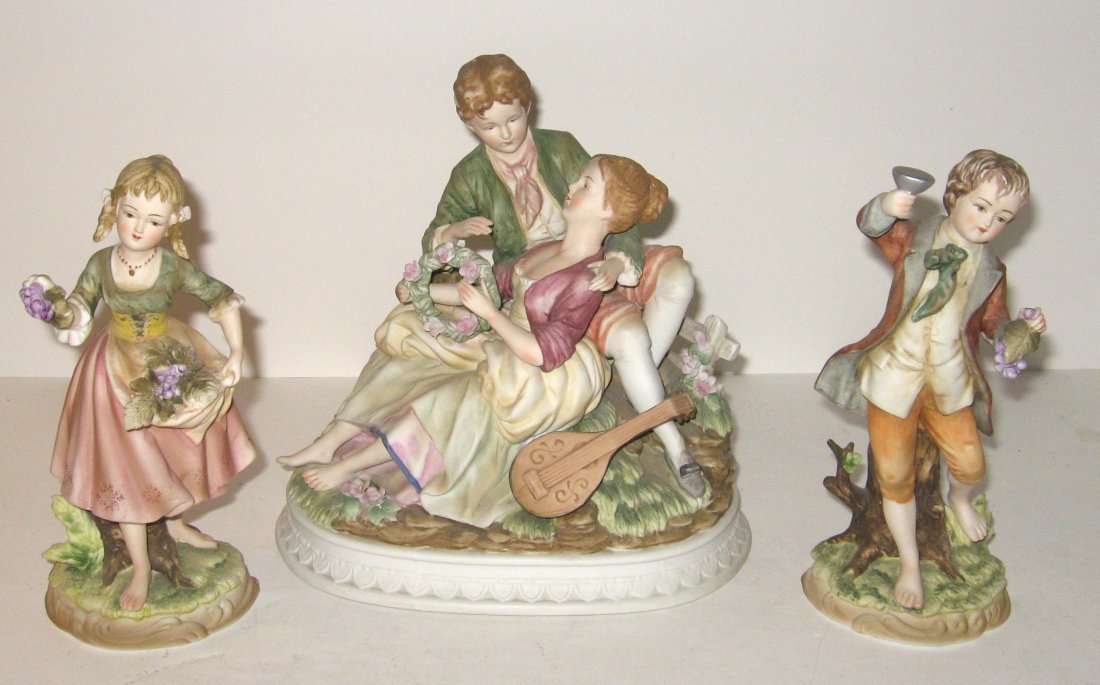 Three piece bisque porcelain grouping,: figural statues of a courting man and women with a two side figurine of a young boy and girl picking grapes, marked with red numbers, 9 1/2" ht.
