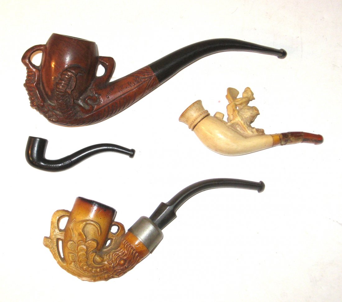 Four vintage meerschaum and wood pipes,: including two with claws and one with a women and a fan, small black marked kookoo wood claw marked Griff LV Saint Claude, 6" long.