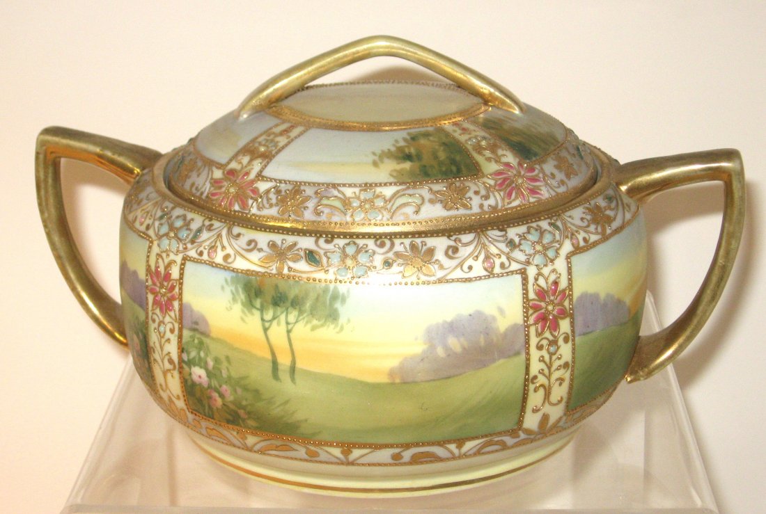 Nippon two handle covered jar,: squatty form decorated with pictorial scenic panels framed with gold scrolling and colorful flowers, marked 9" wide.