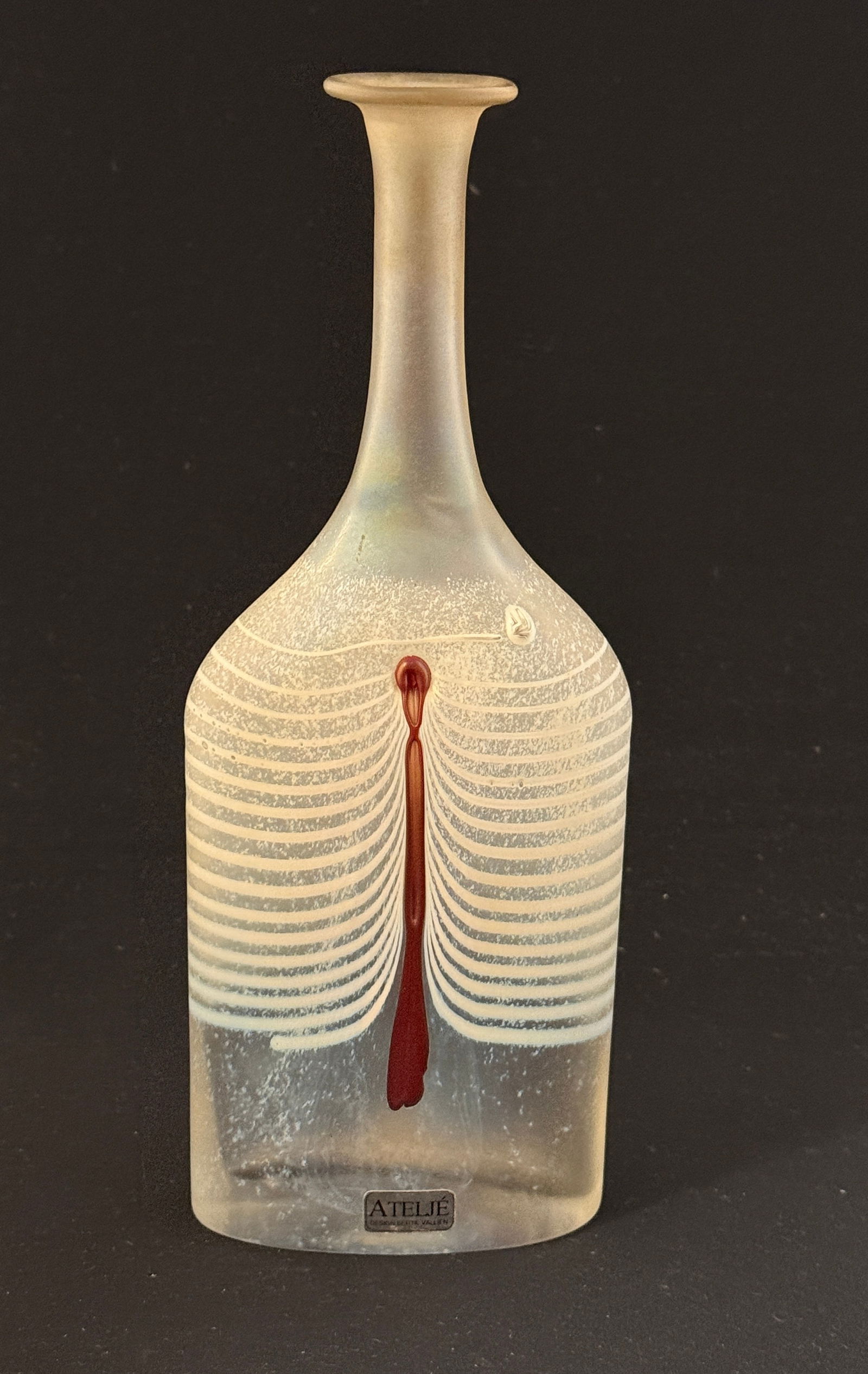 Boda Bottle Form Vase: Boda Bertil Vallien bottle form vase with white draping with red dripping, signed and paper label; 9 1/4" ht. CONDITION: no chips, cracks, repairs, or material defects found, Jaremos attempts to call