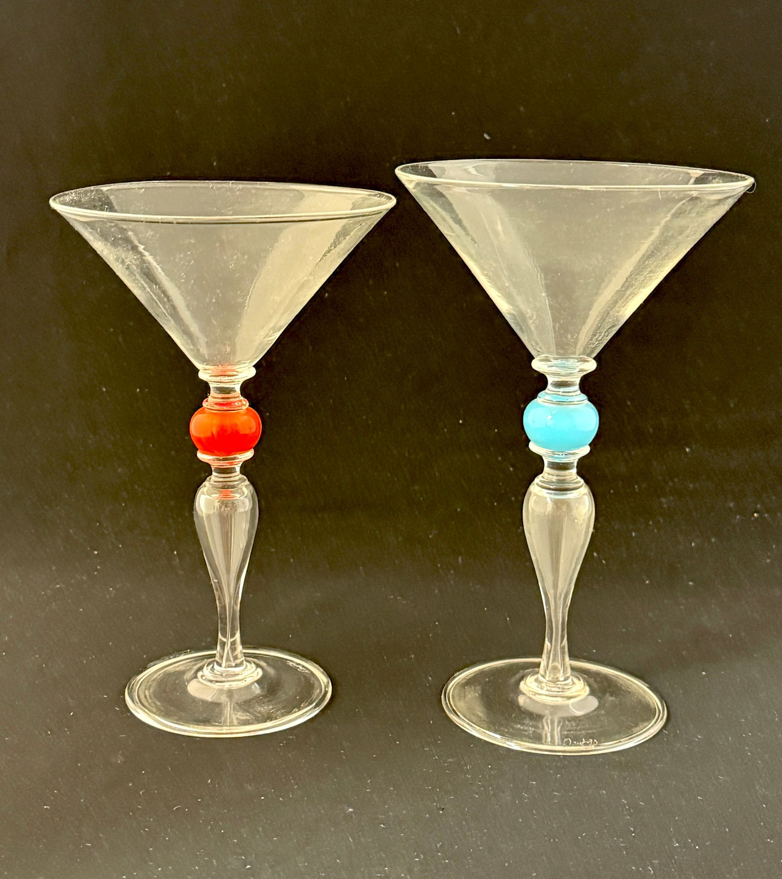 Pair of Dante Marioni Goblets: Pair of Dante Marioni clear glass goblets, one with red ball standard and one with blue ball, signed; 7 3/8" ht. CONDITION: no chips, cracks, repairs, or material defects found, Jaremos attempts to ca