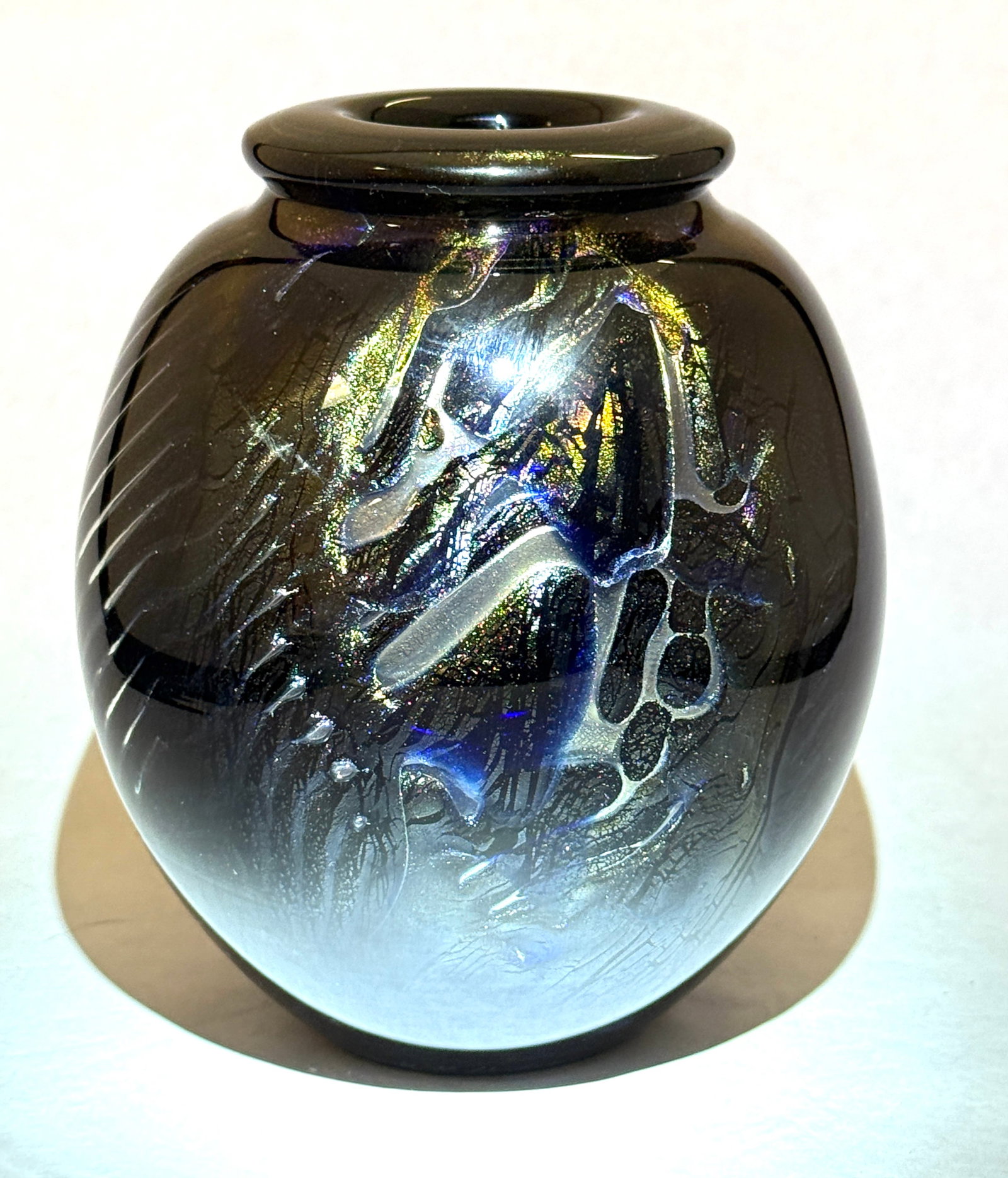 David Huchthausen Vase: David Huchthausen art glass vase, black with gold, silver, and blue leaf and swirling encased design, signed David R. Huchthausen1977; 6" ht. CONDITION: no chips, cracks, repairs, or material defects 