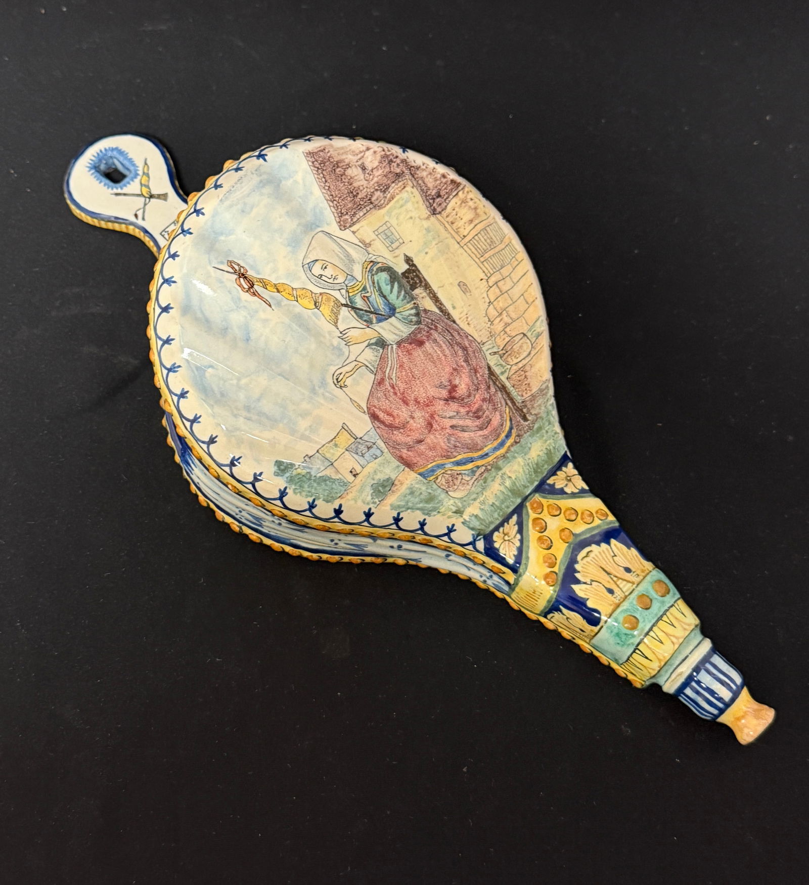 HB Bellows with Bretonne: HB French faience bellows with Bretonne; length 13 1/8". c. 1883-1904. PROVENANCE: Valerie Howard's London Shop. CONDITION: Quimper has a propensity to have minor chips, glaze loss/wear and crazing. J