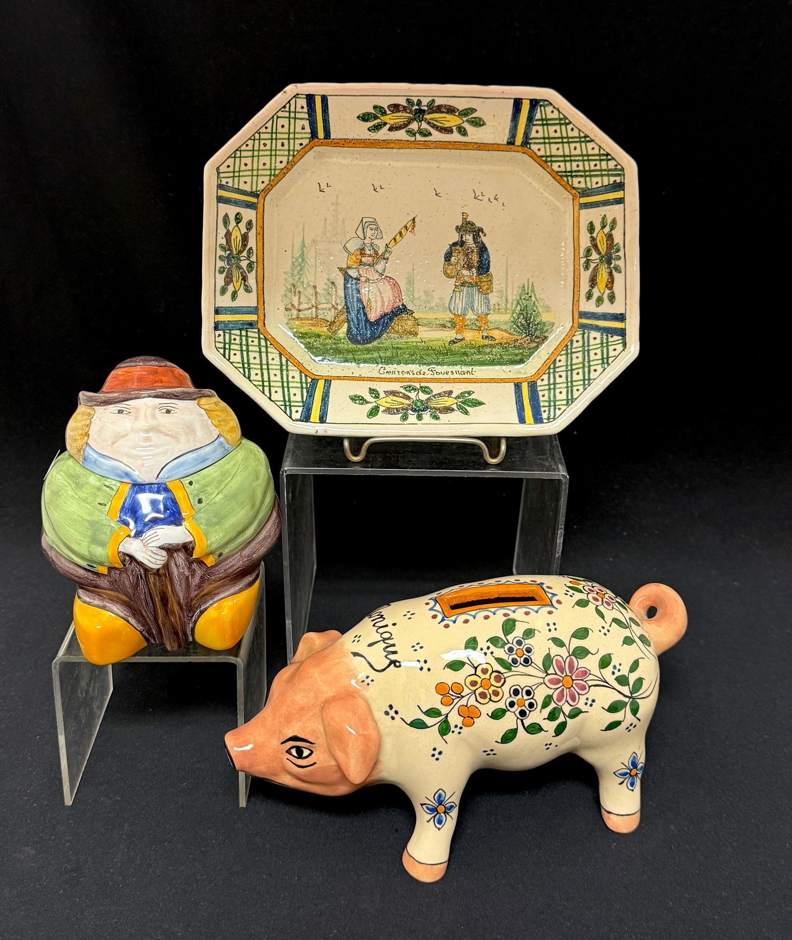 3 Quimper Items: 3 Quimper French faience including a small HB Quimper platter with Breton couple "Fouesnant", an HB HenRiot Fat Man jar; and an HB Quimper piggy bank "Monique"; pig length 7 1/2". CONDITION: Quimper h
