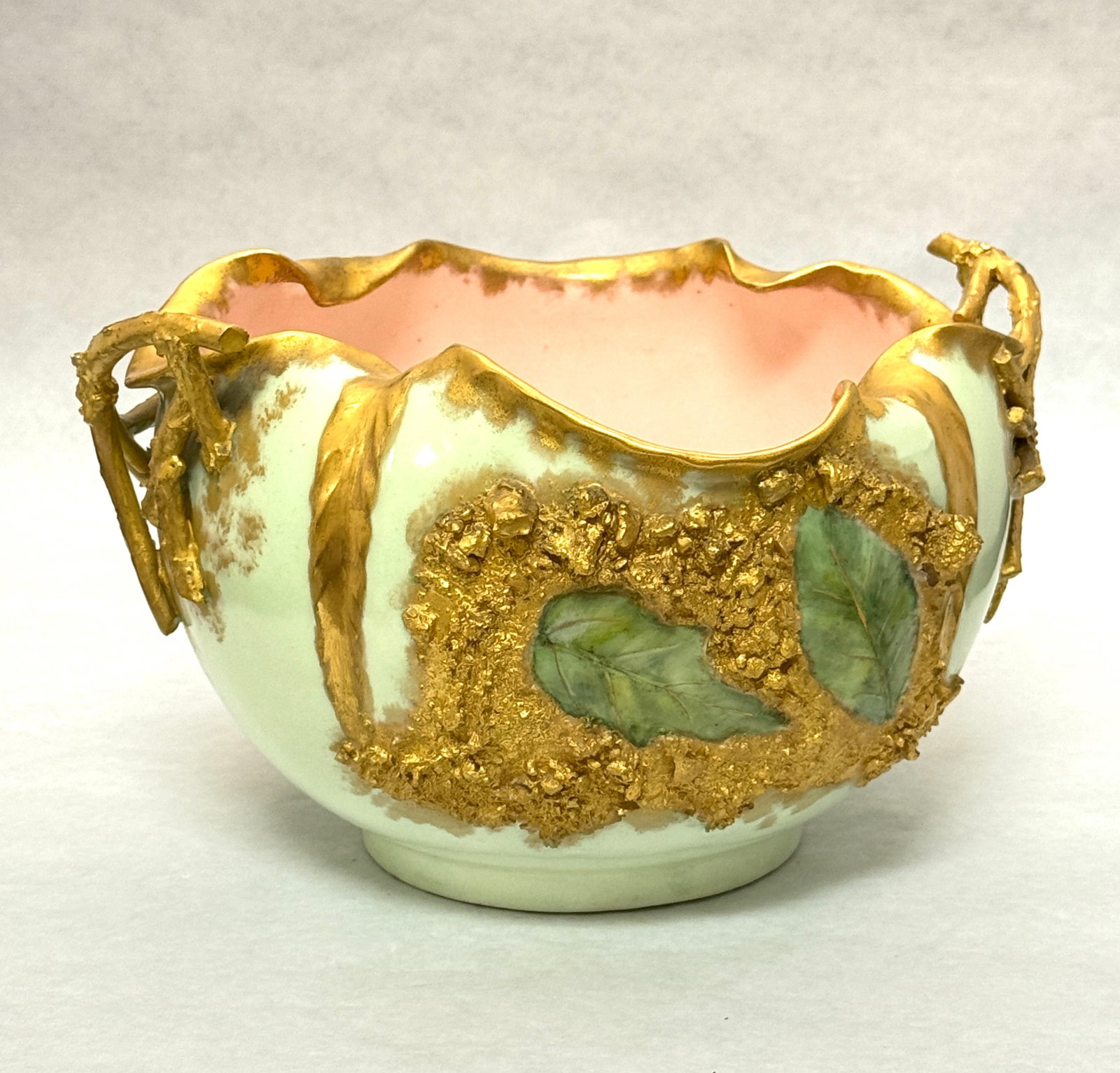 Lotus ware Bowl: Green Lotus ware green bowl with gold trim, branch handles and Applica around green leaves and a pink interior, marked; diameter 8 1/2". CONDITION: no chips, cracks, repairs or material defects found.