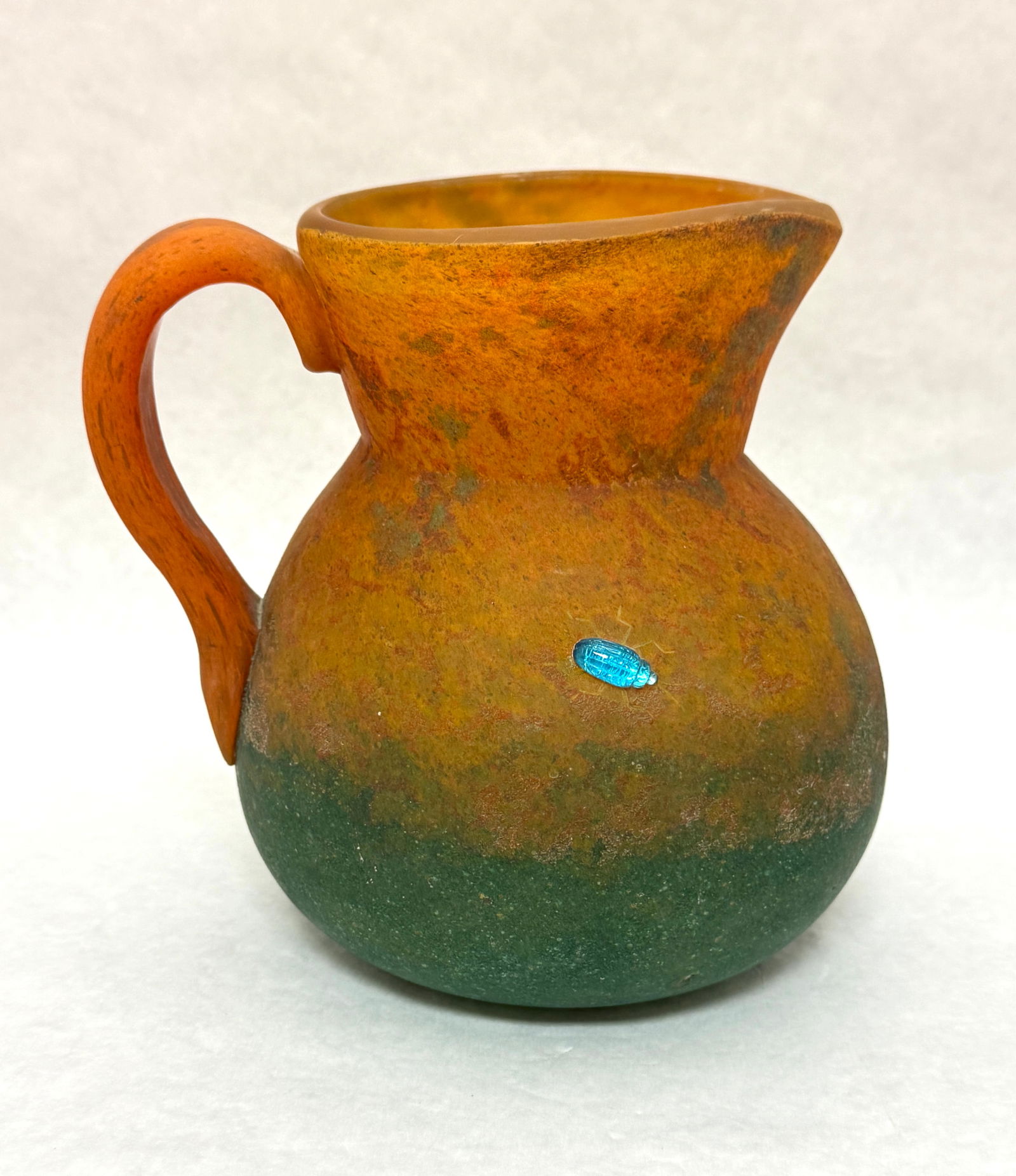 Daum Nancy Pitcher: Daum Nancy mottled amber to green pitcher with applied jeweled beetles, signed Daum Nancy; ht 7". CONDITION: no chips, cracks, repairs or material defects found, Jaremos attempts to call any material