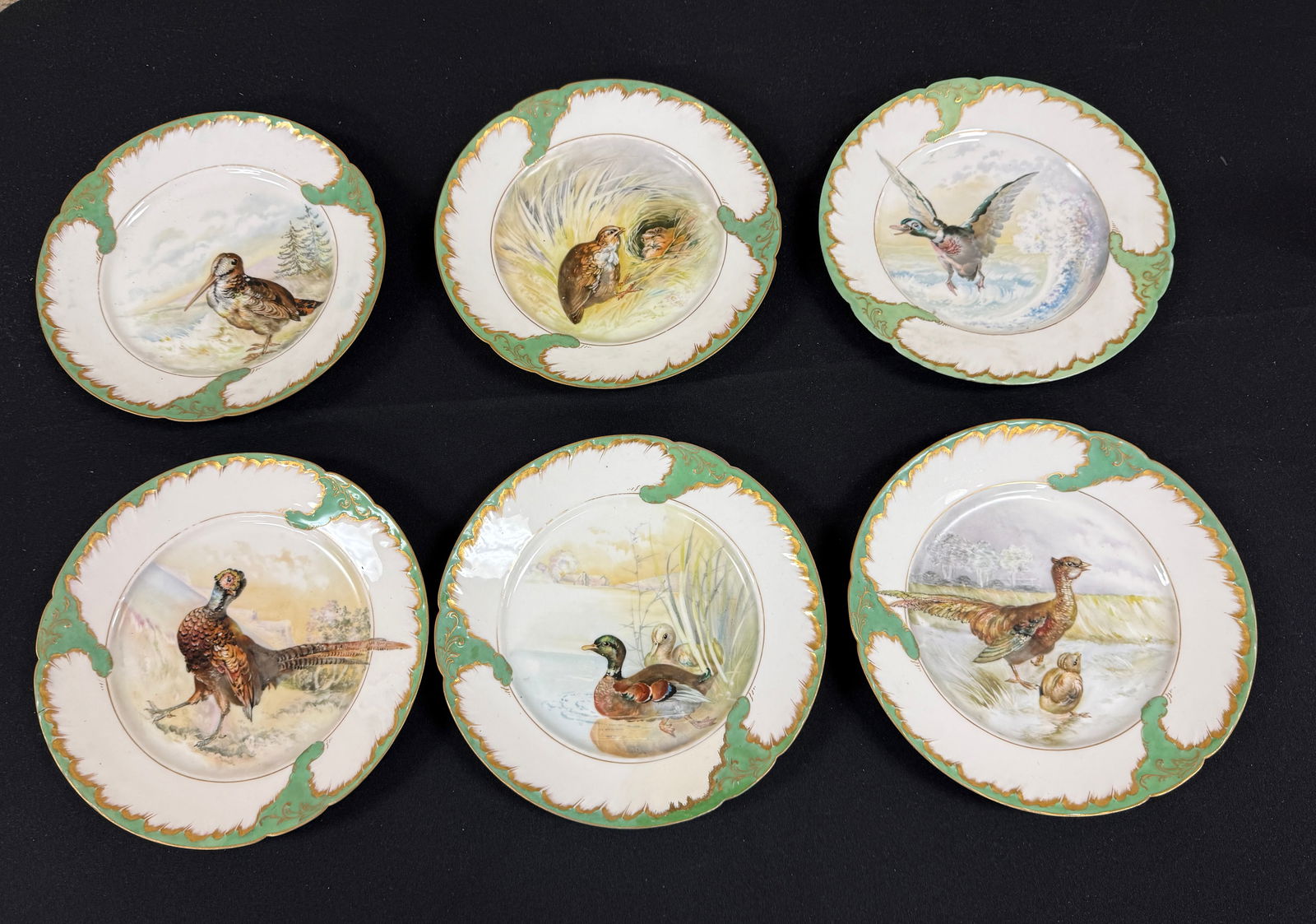 6 Pairpoint Porcelain Plates: 6 Pairpoint Porcelain plates in white with green scrolling rims all decorated with birds, all signed, diameter 9 1/2". CONDITION: no chips, cracks, repairs or material defects found, Jaremos attempts