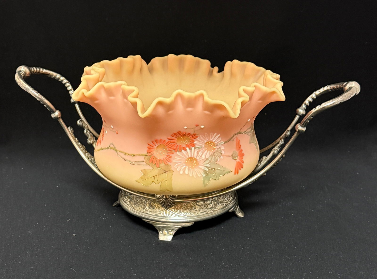 Burmese Uranium Bride's Basket: Mt. Washington Burmese uranium bride's basket with enameled mums and a ruffle top set in a marked Pairpoint stand; diameter 9 1/2". CONDITION: no chips, cracks, repairs or material defects found, Jare