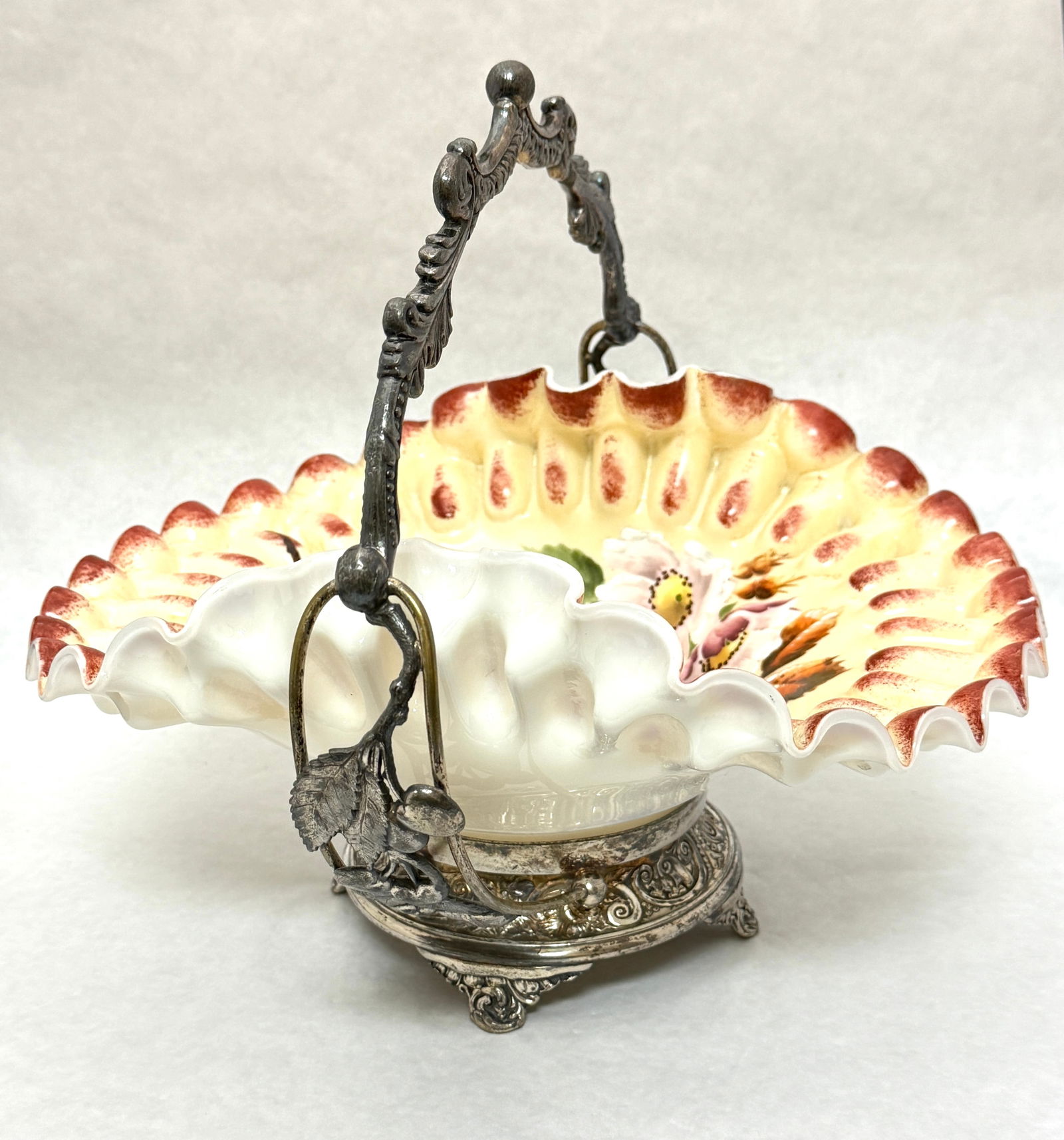 Victorian Bride's Basket: Victorian encased satin glass bride's basket with enameled floral d?cor and red tinged ruffle rim set in a marked Pairpoint associated frame; ht 10 1/2". CONDITION: no chips, cracks, repairs or materi