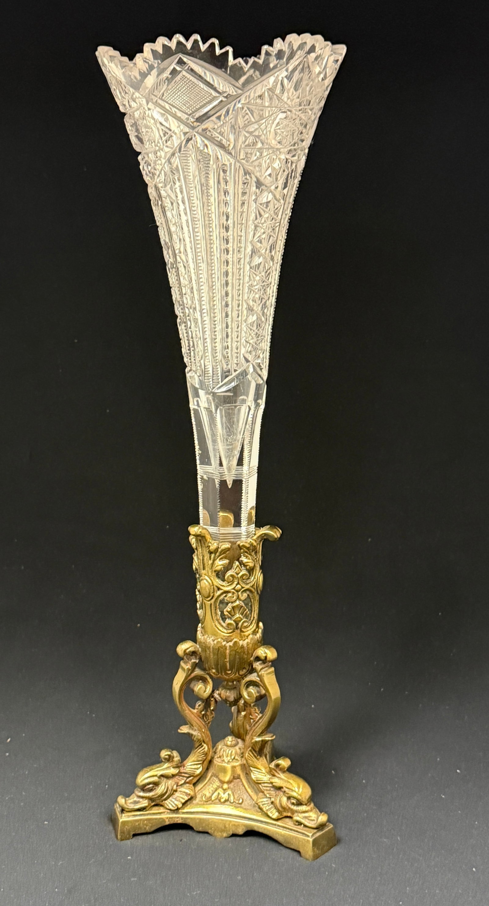 Cut Glass Trumpet Epergne: Cut glass trumpet vase set in a set in a three footed dolphin base, 16" ht. CONDITION: no chips, cracks, repairs, or material defects found, Jaremos attempts to call any material flaw that affects the