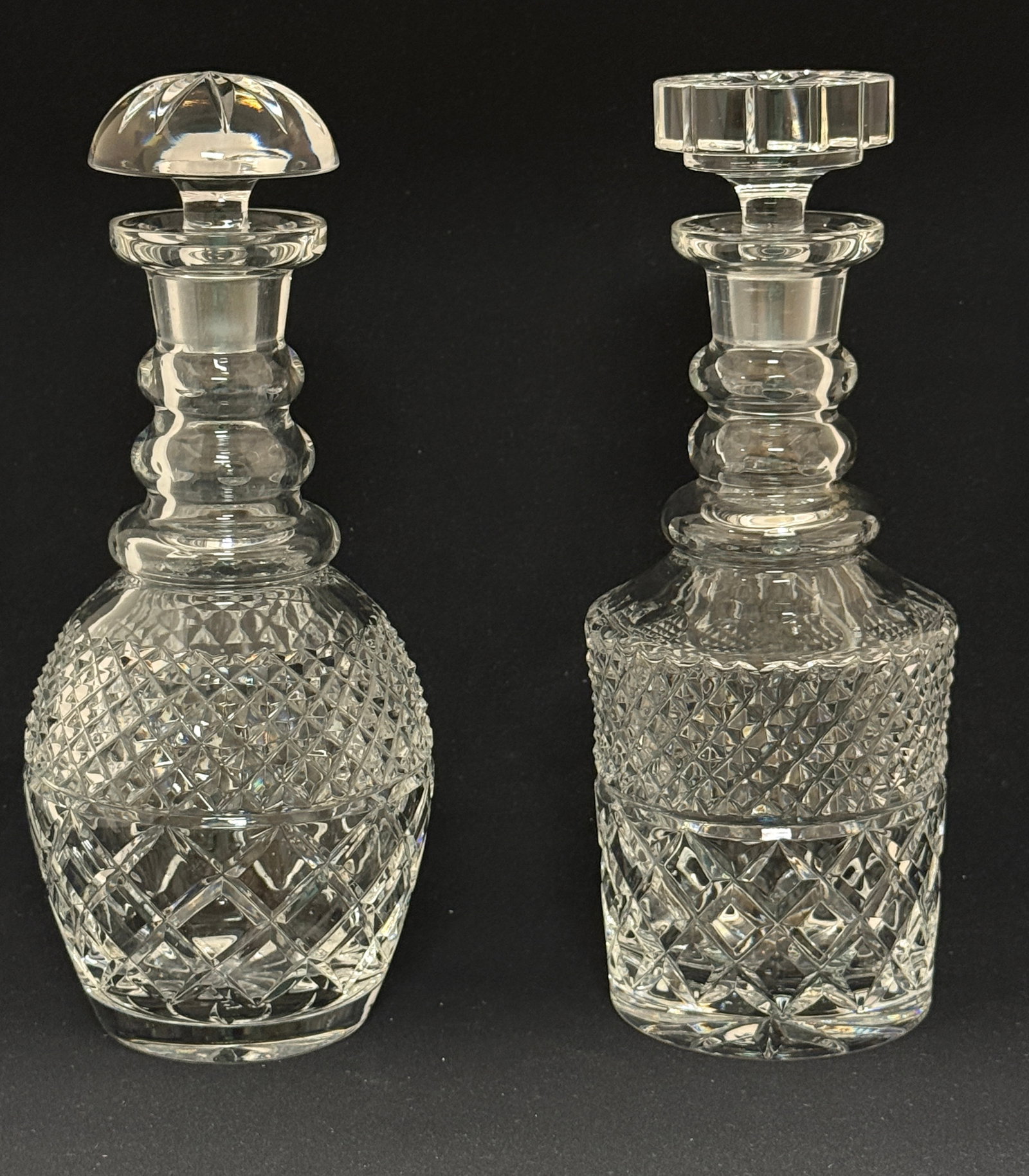 2 Cut Glass Decanters: 2 cut glass decanters in the Waterford style, 11 1/2" ht. CONDITION: roughness to inside of one of the stoppers.