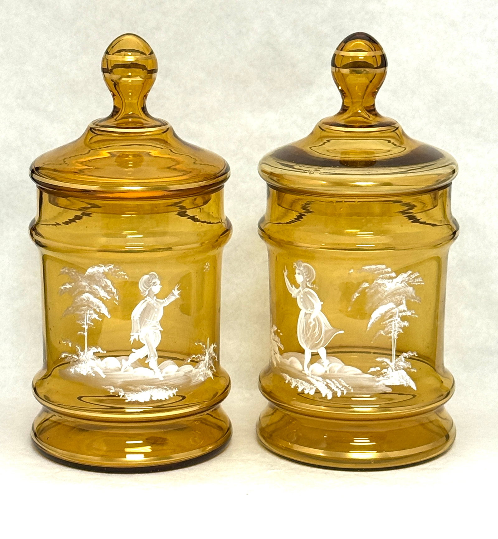 2 Amber Mary Gregory Biscuit Jars: 2 amber Mary Gregory biscuit jars; ht. 10". CONDITION: no chips, cracks, repairs, or material defects found, Jaremos attempts to call any material flaw that affects the price, but minor scratches and 