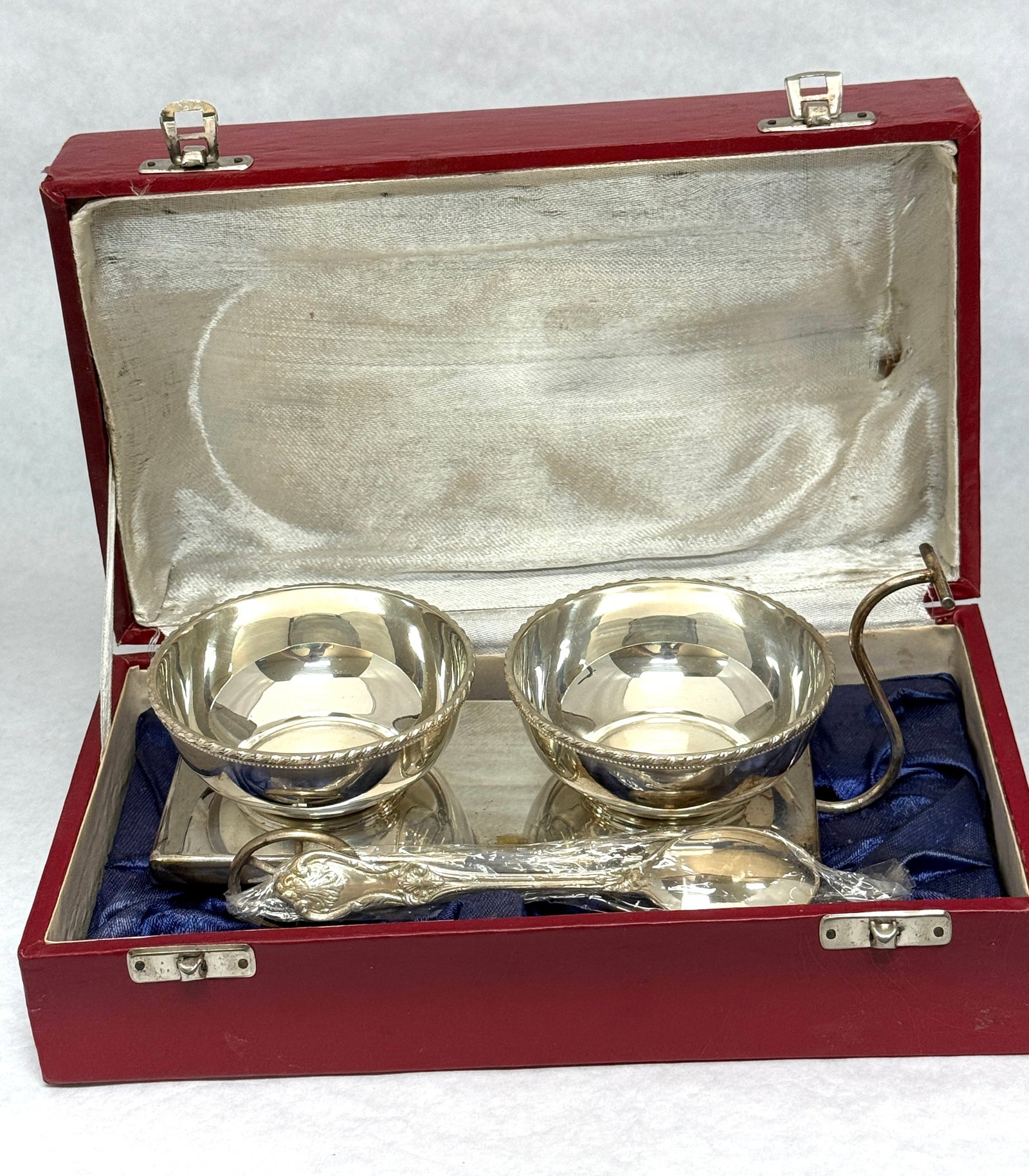 Silver Plate Condiment Set: Silver plate condiment set with two bowls set on a wagon tray with a spoon, in gift box; gift box 10" length. CONDITION: no chips, cracks, repairs, or material defects found, Jaremos attempts to call 