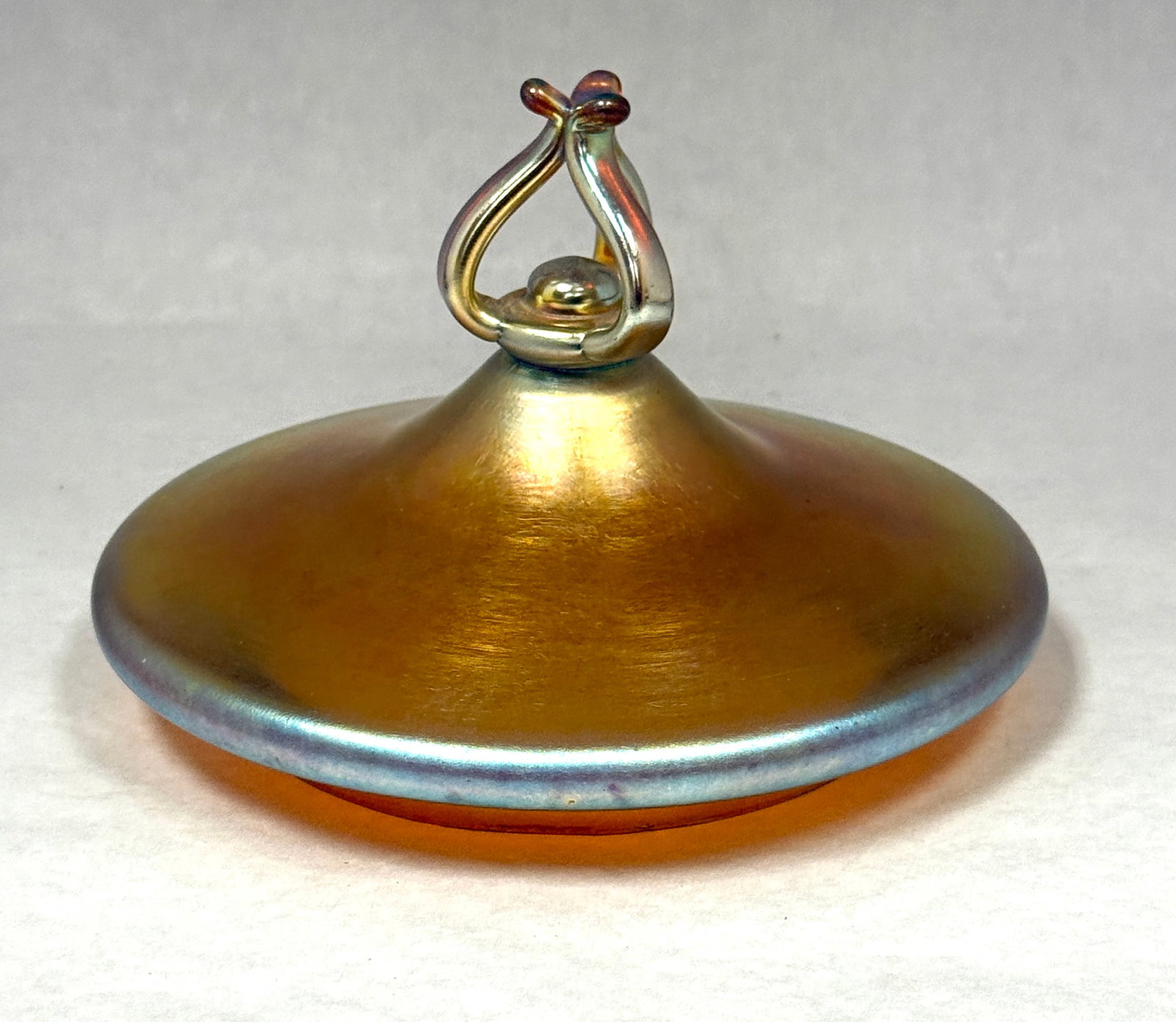 Steuben Gold Aurene Lid: Steuben gold aurene lid with decorative finial; fitting diameter 4 5/8". CONDITION: no chips, cracks, repairs, or material defects found, Jaremos attempts to call any material flaw that affects the