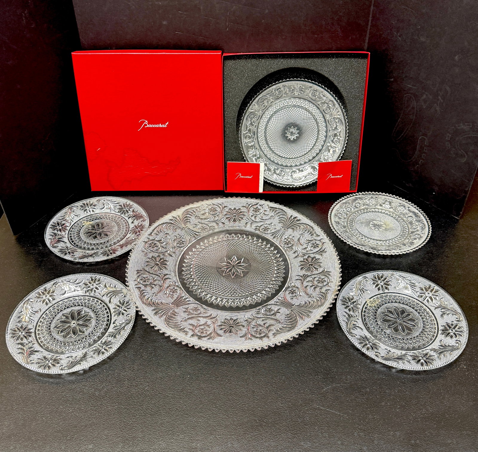 Set of Baccarat Plates: Set of Baccarat plates in lacy pattern, platter and 5 plates, one in box; platter diameter 16". CONDITION: no chips, cracks, repairs, or material defects found, Jaremos attempts to call any material
